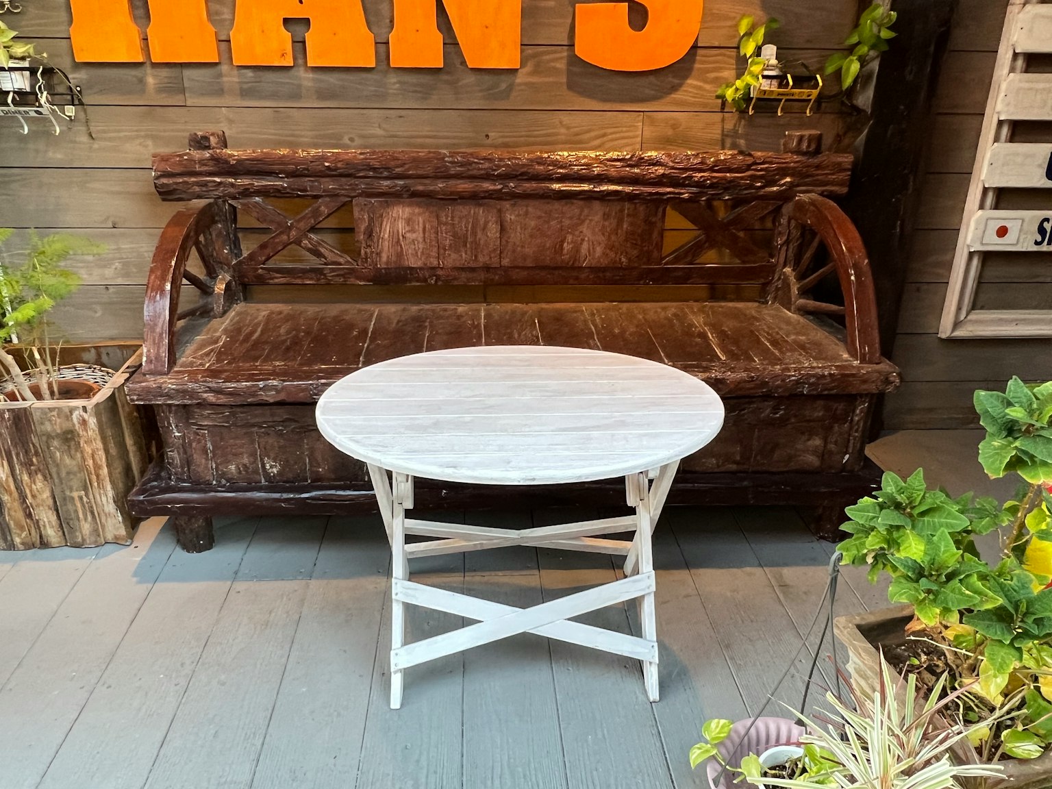 Un divano in legno rustico con un tavolo rotondo bianco in un caffè