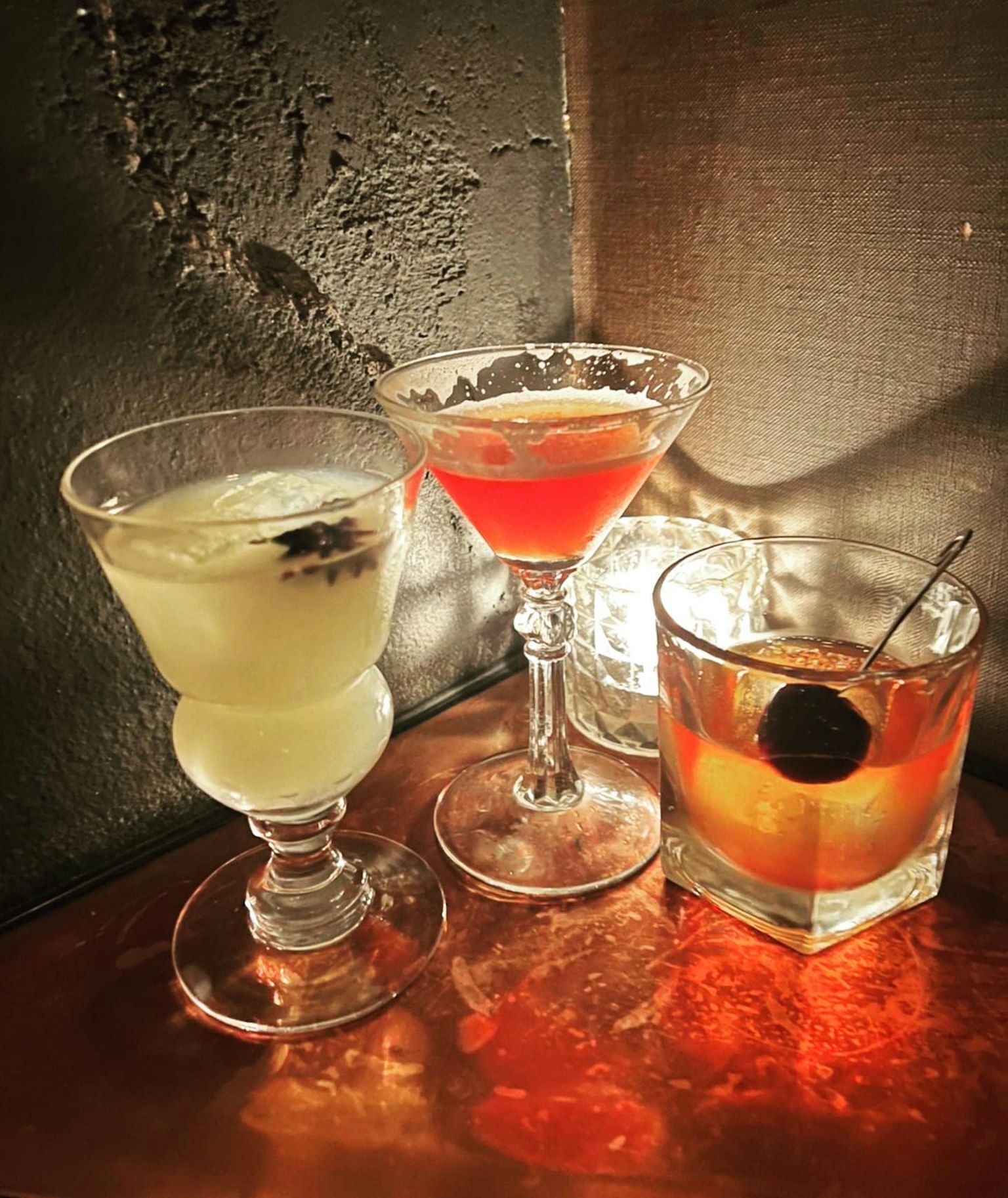 Tre bicchieri di cocktail con bevande colorate su un tavolo