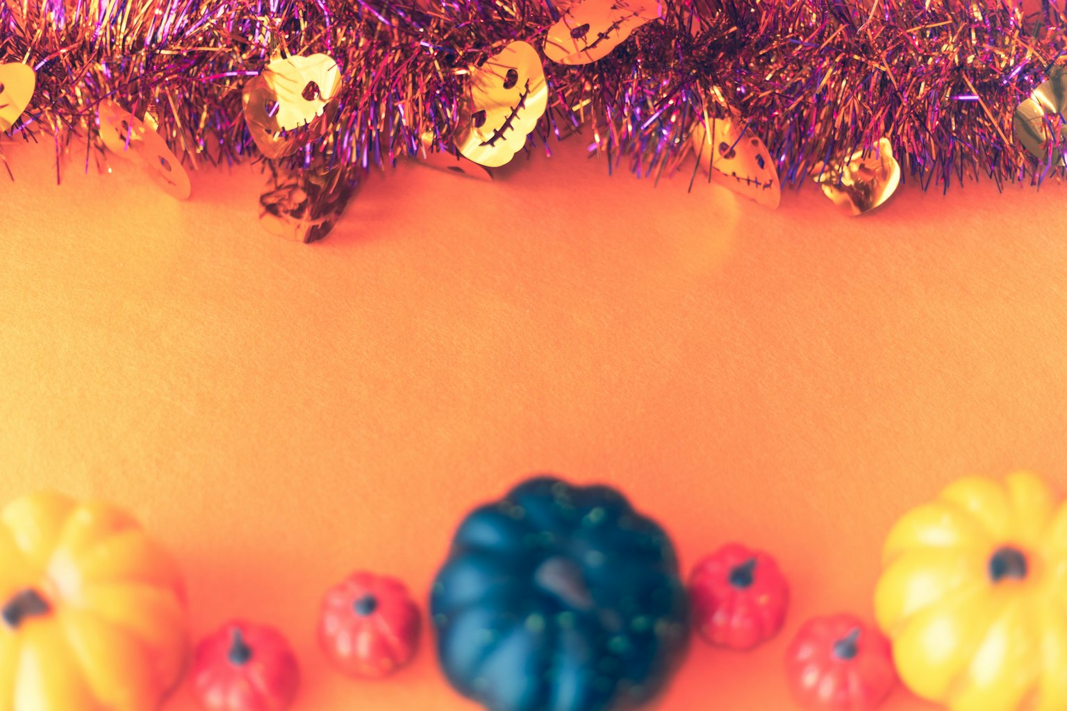 Calabazas coloridas y decoraciones de Halloween sobre un fondo naranja