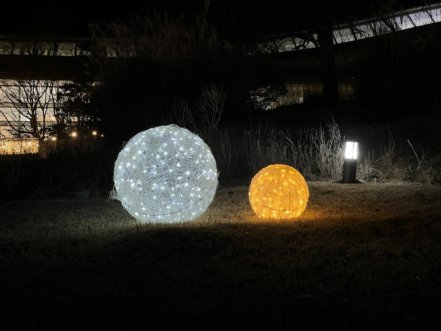 Sfere decorative luminose bianche e arancioni su sfondo scuro