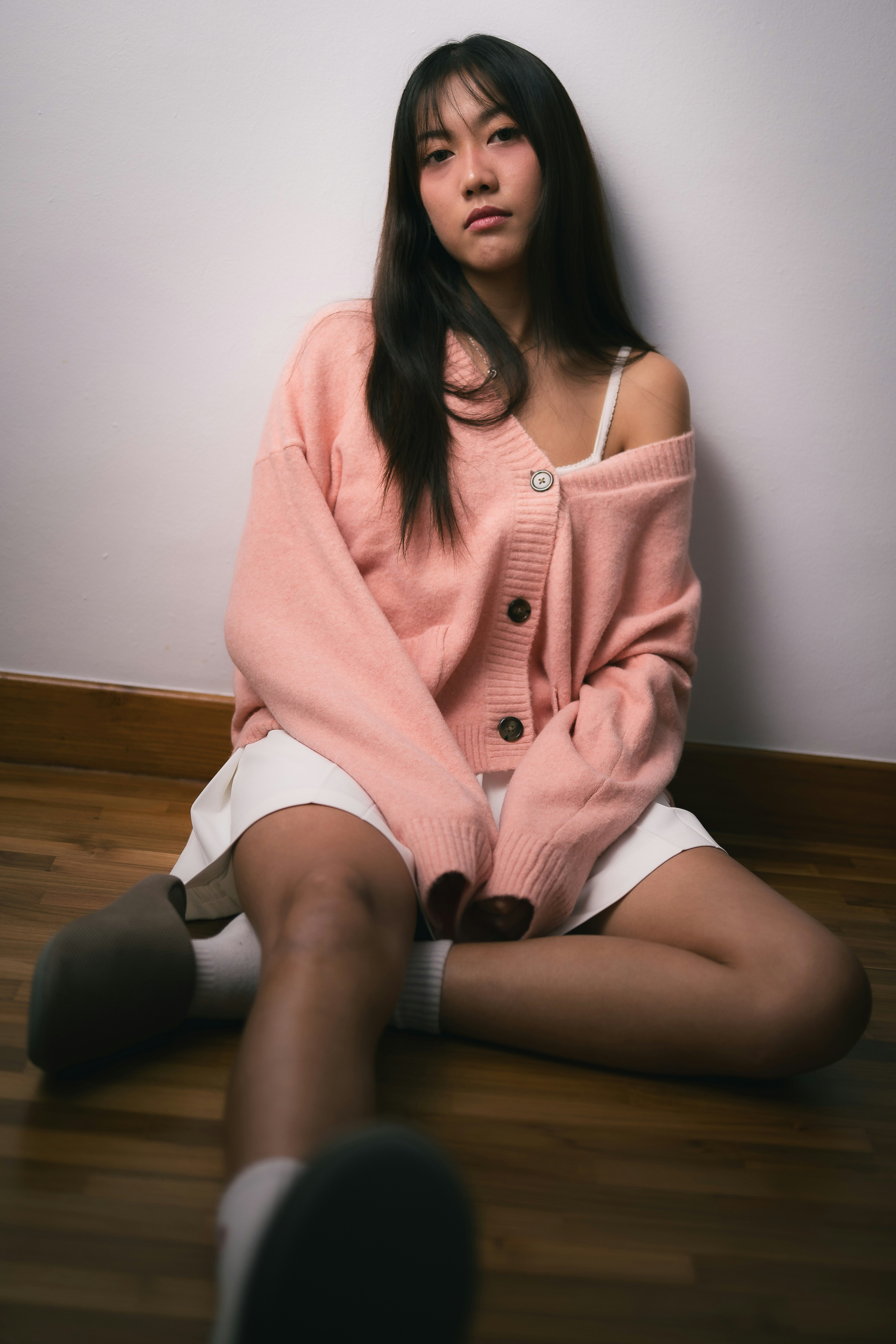 やわらかな表情の女性が室内で座っている
