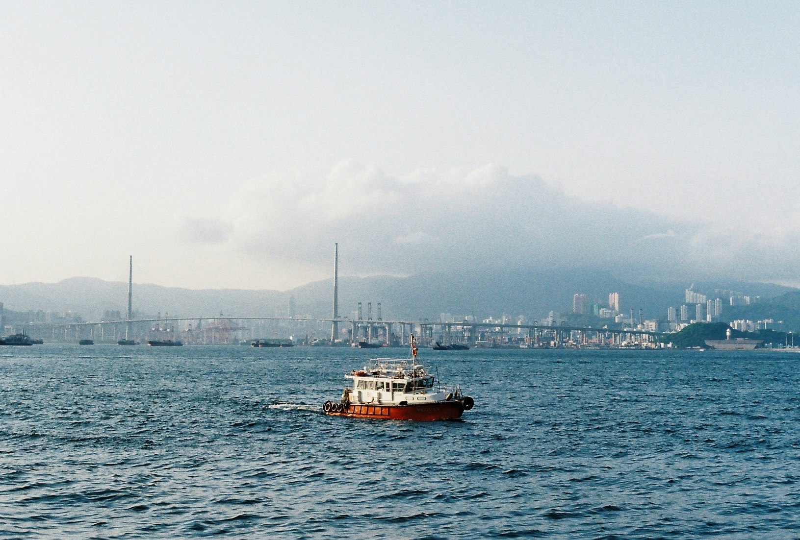 海上を走るフェリーと港の工業施設のある湾の風景