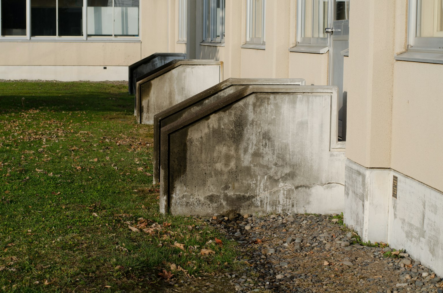 Betontreppen neben einem Gebäude mit Gras und Kies