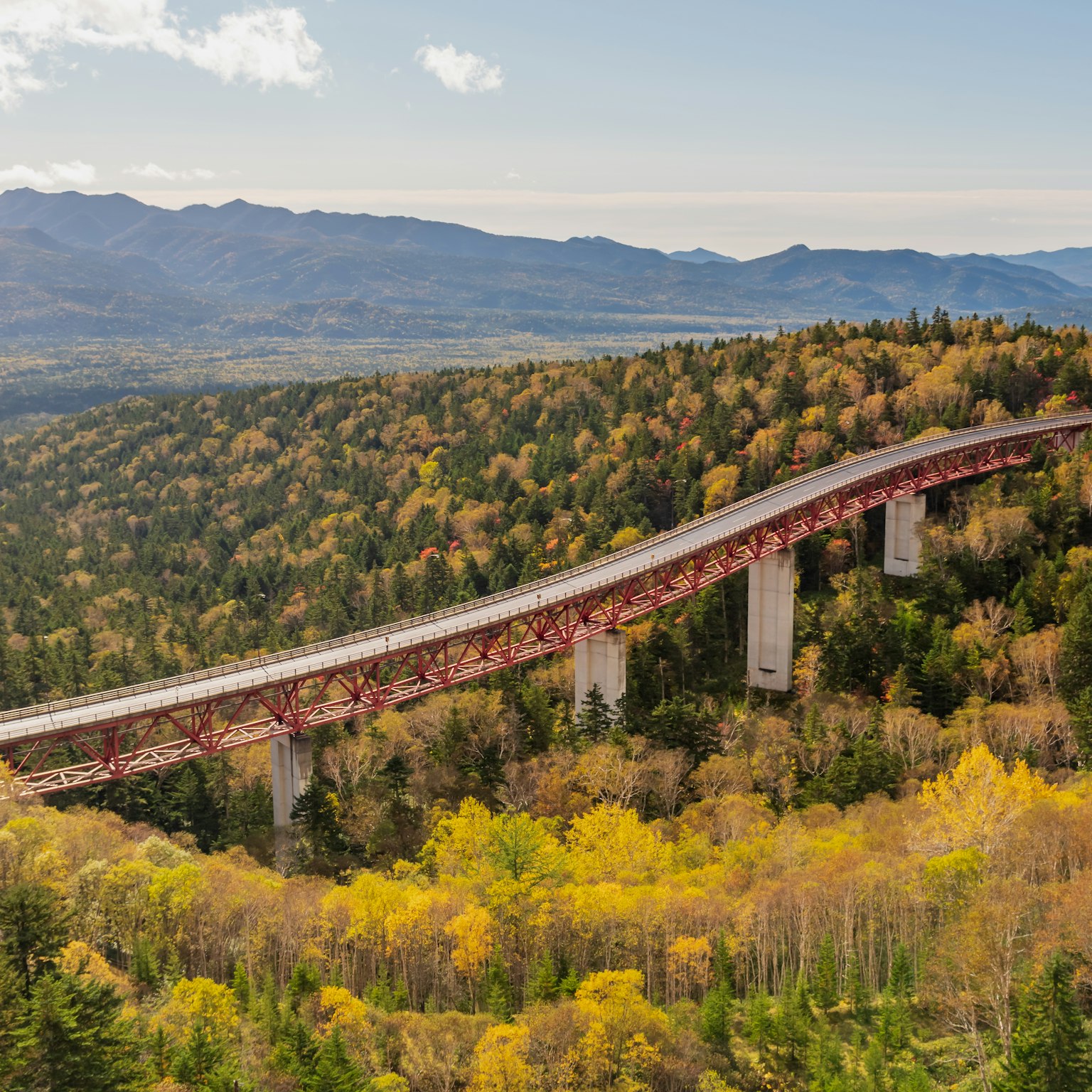 Un pont pittoresque entouré de feuillage d'automne et de montagnes