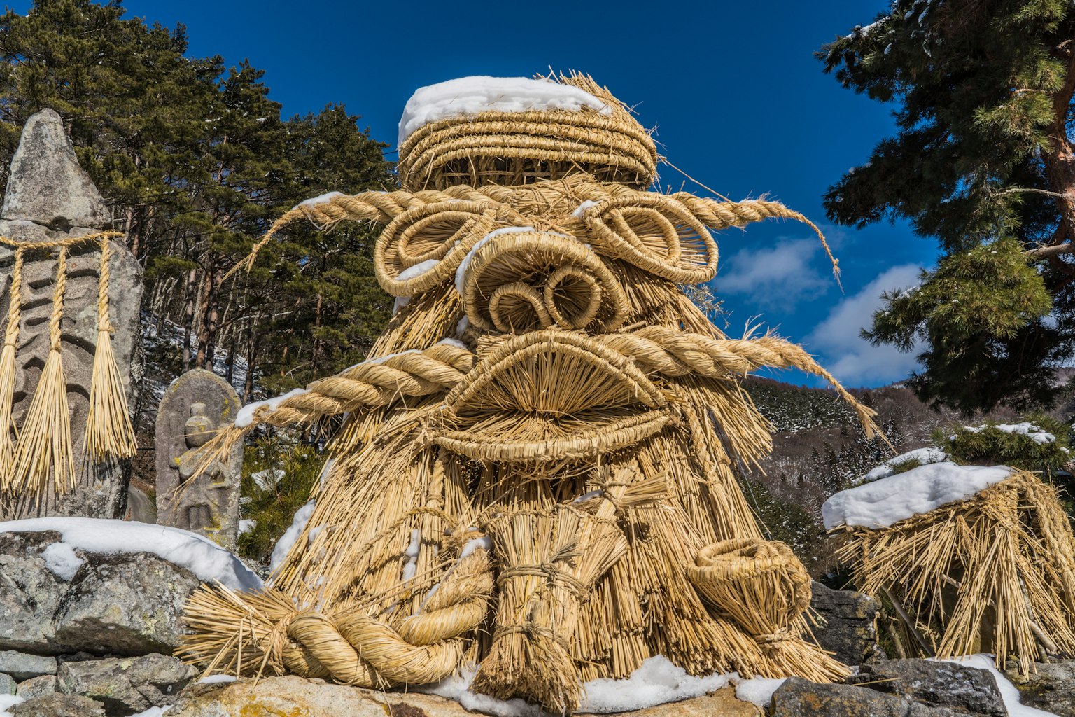 Une statue de bête mystique en paille se dresse dans un paysage enneigé