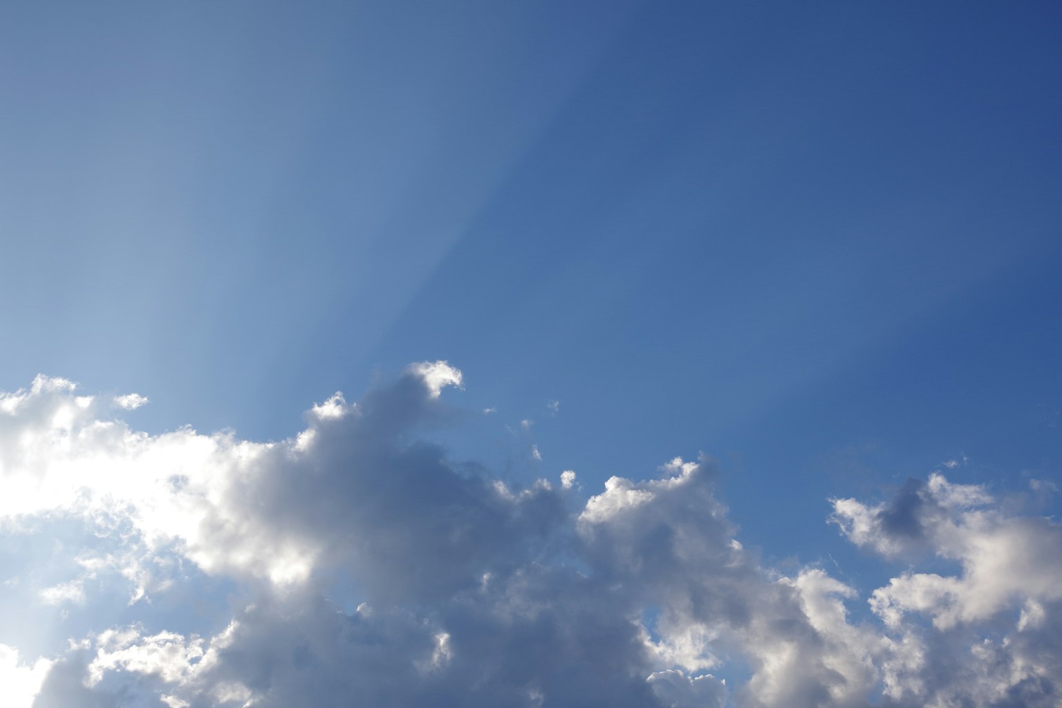 Cielo azul con nubes blancas y rayos de luz