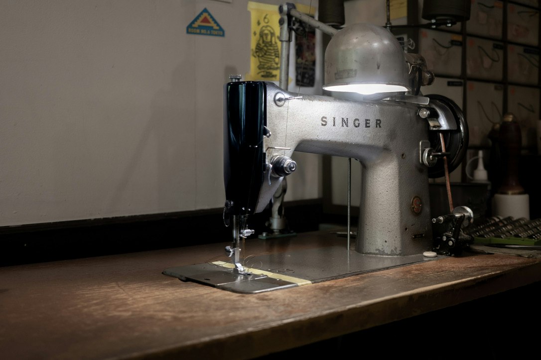 Máquina de coser Singer sobre un banco de taller con herramientas