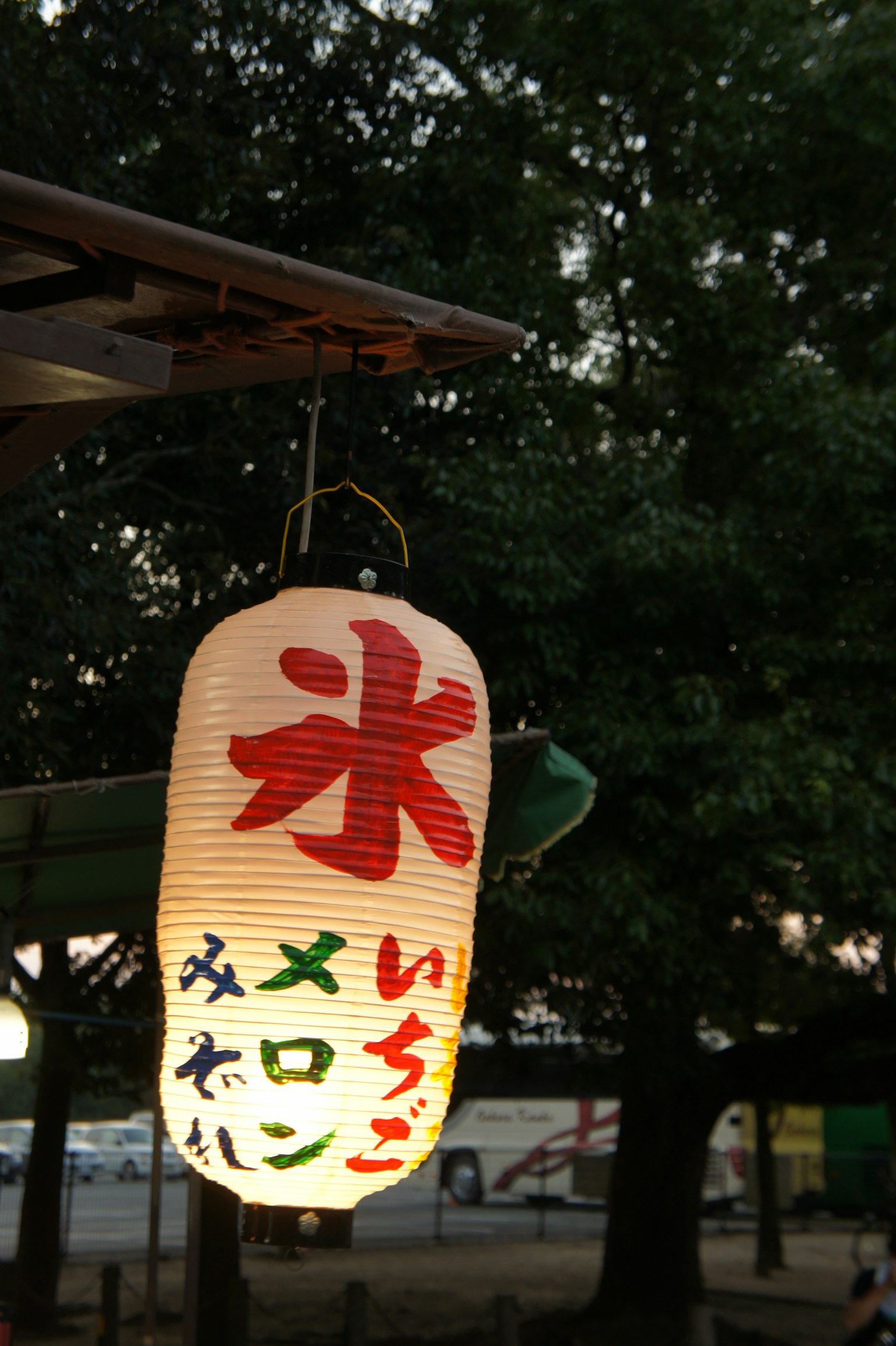 夜晚公园里悬挂的灯笼上有红色文字，写着冰和哈密瓜