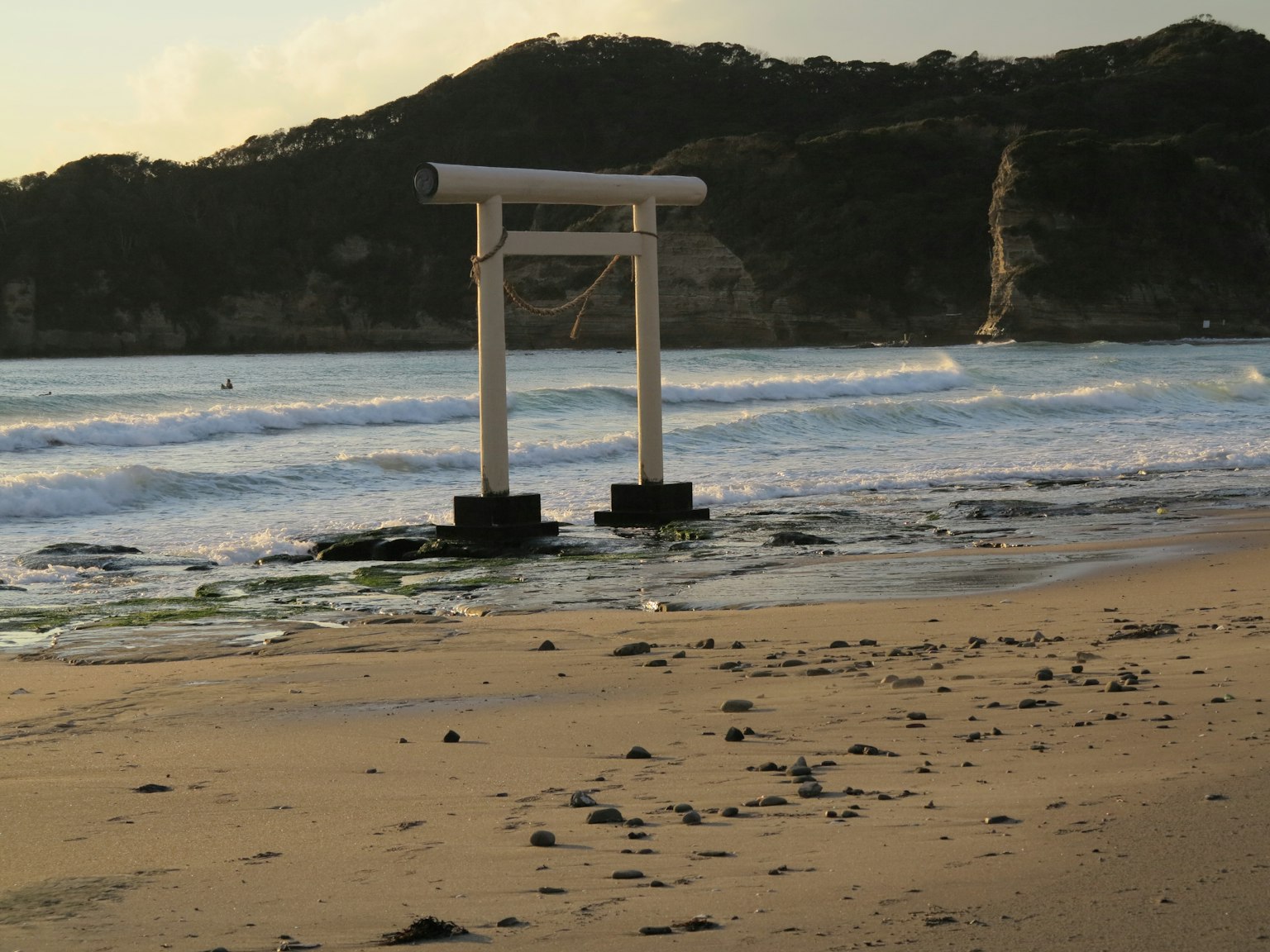 海滩附近的白色鸟居和波浪