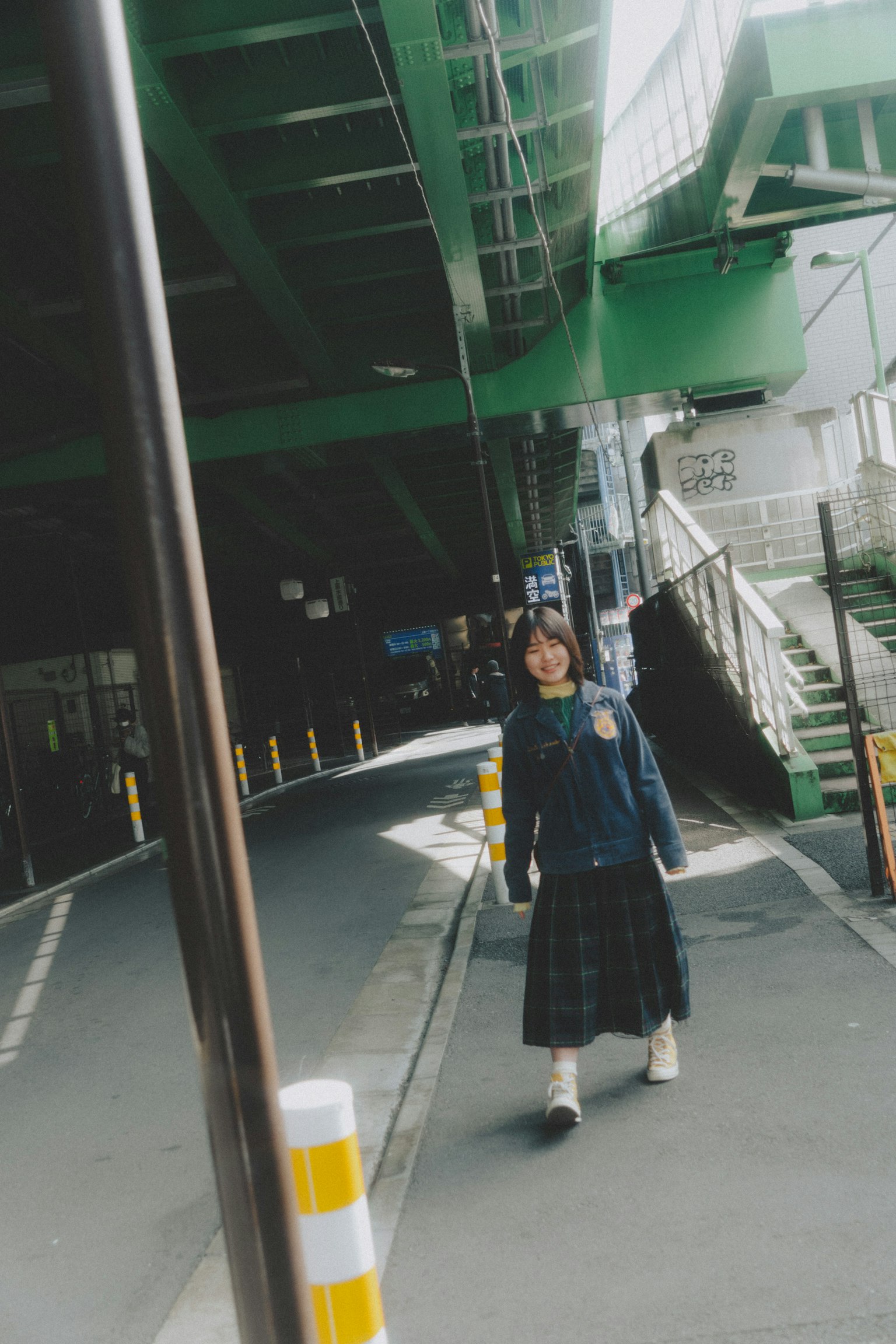 Photo of a woman standing under a green bridge