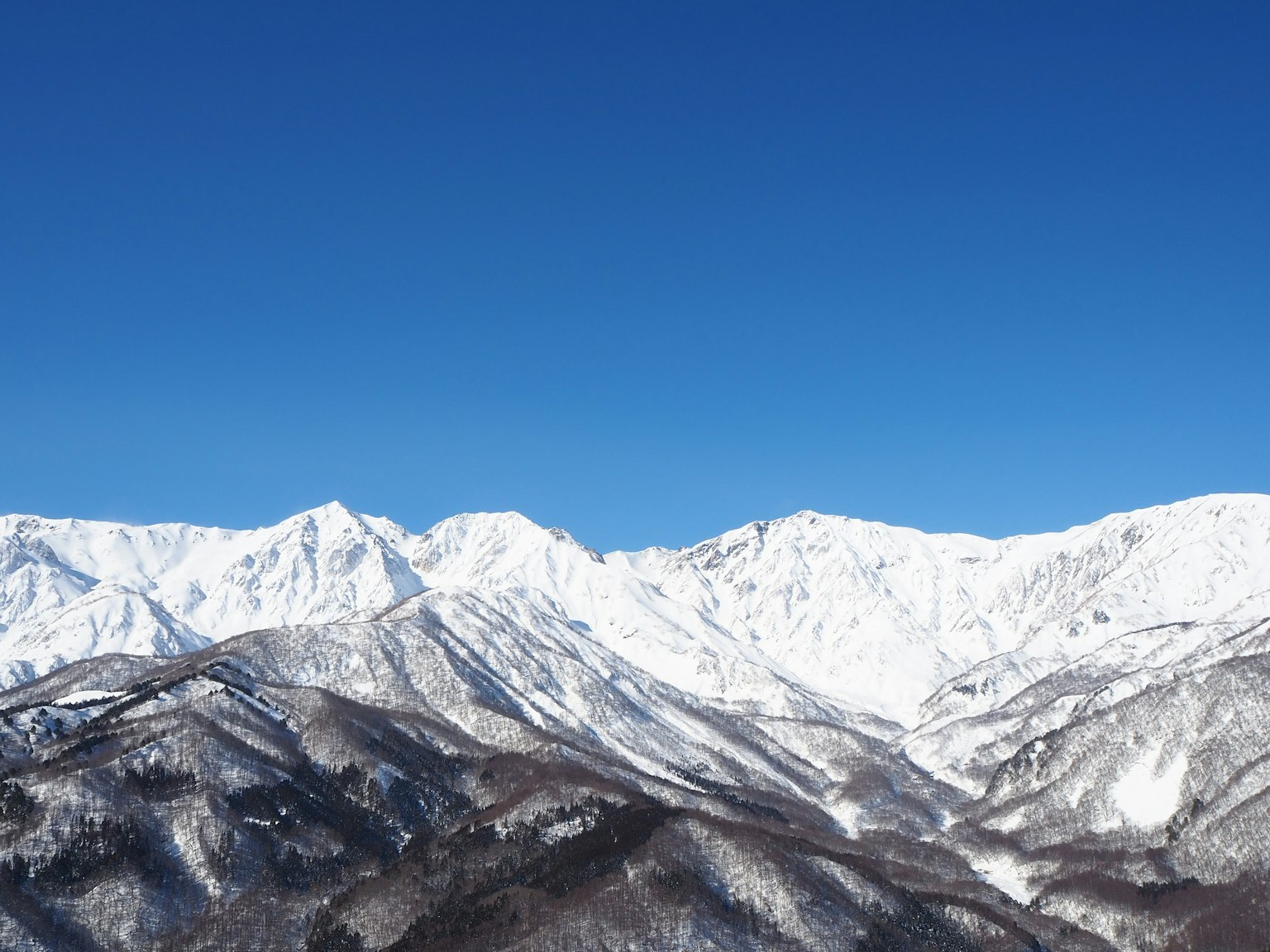 Montagne coperte di neve sotto un cielo blu chiaro