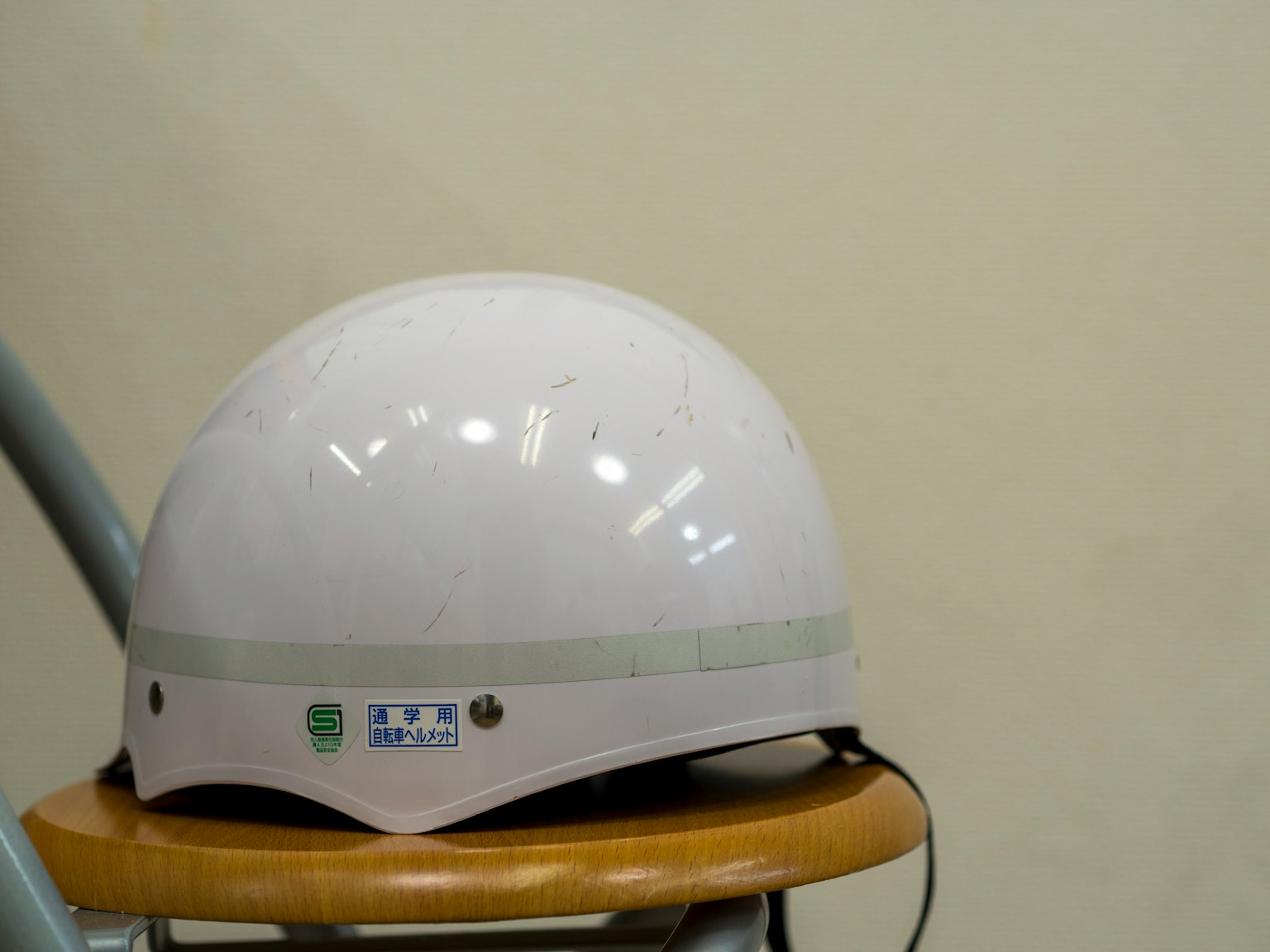 Un casco bianco posato su uno sgabello di legno