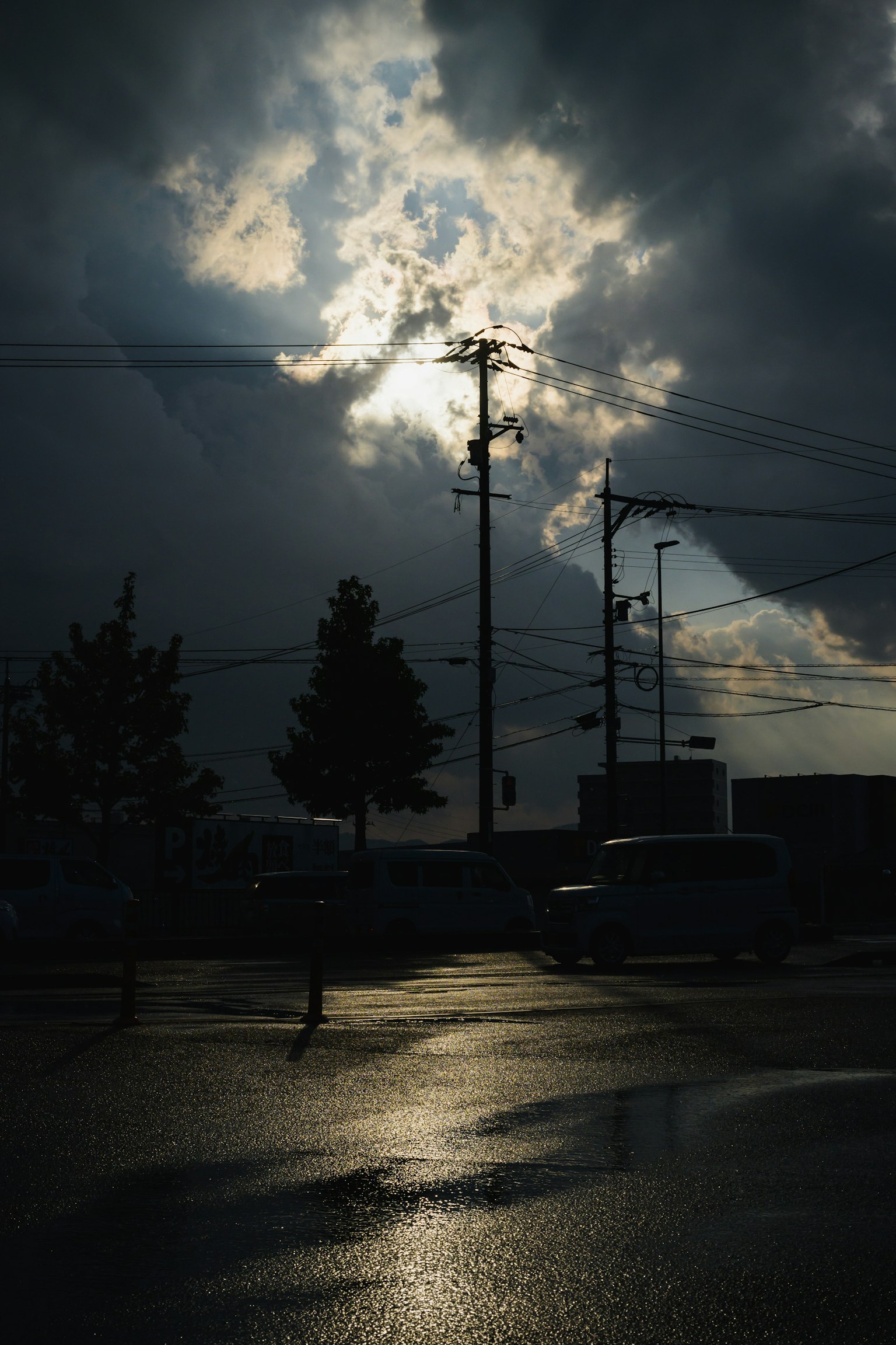 光線穿過黑暗的雲層，濕潤路面的反射