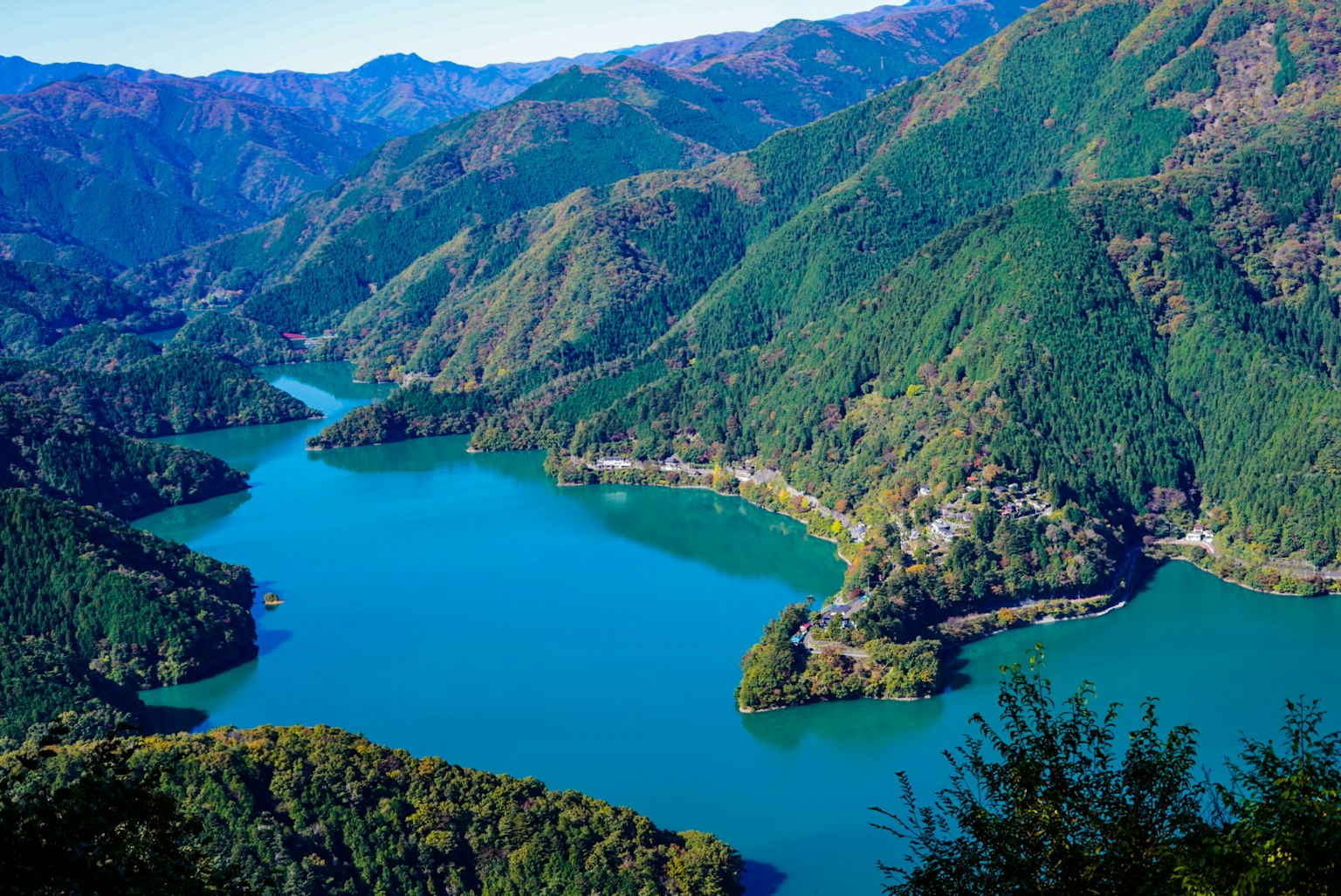 Scenic view of a blue lake surrounded by green mountains