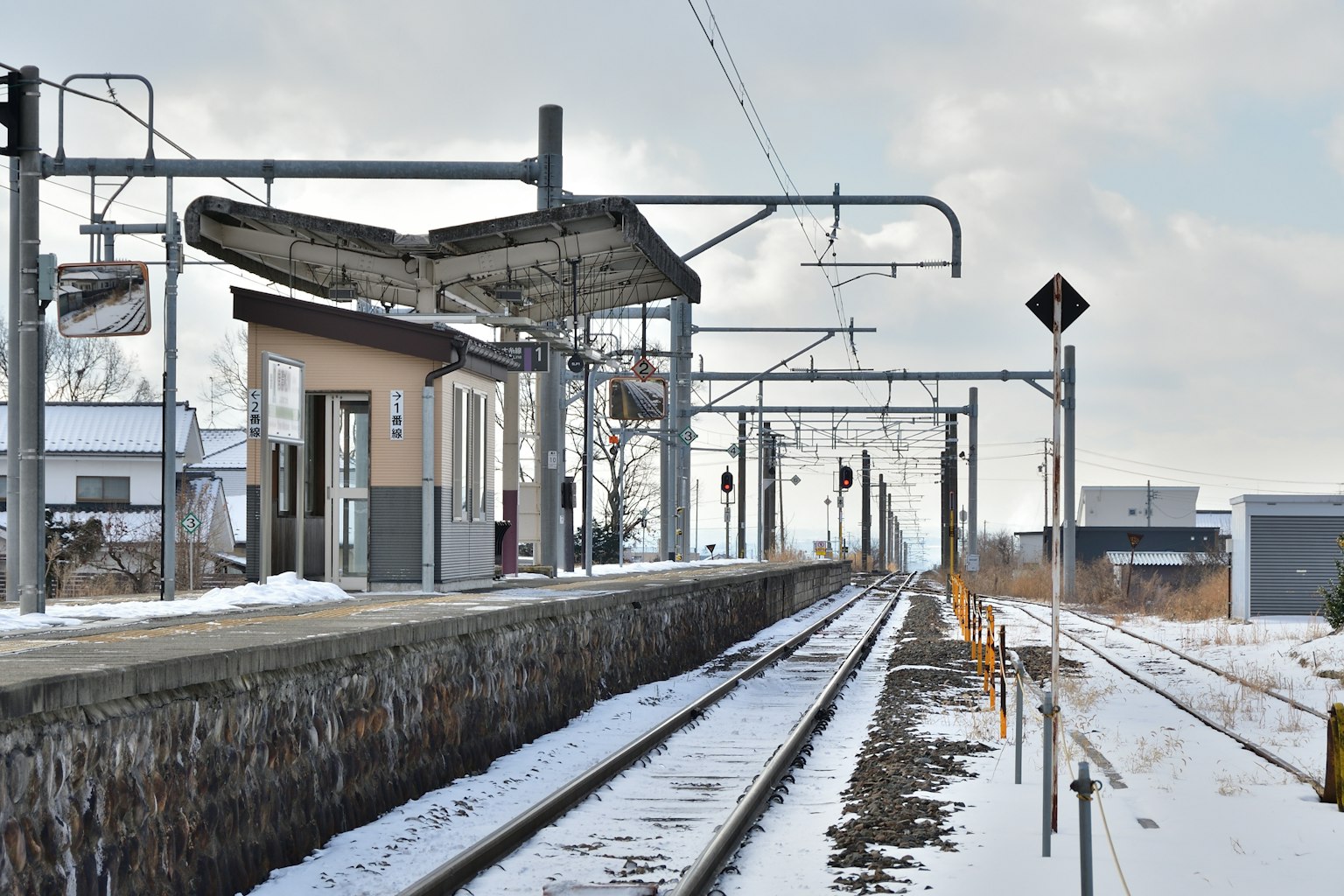 Platform stasiun yang tertutup salju dengan rel