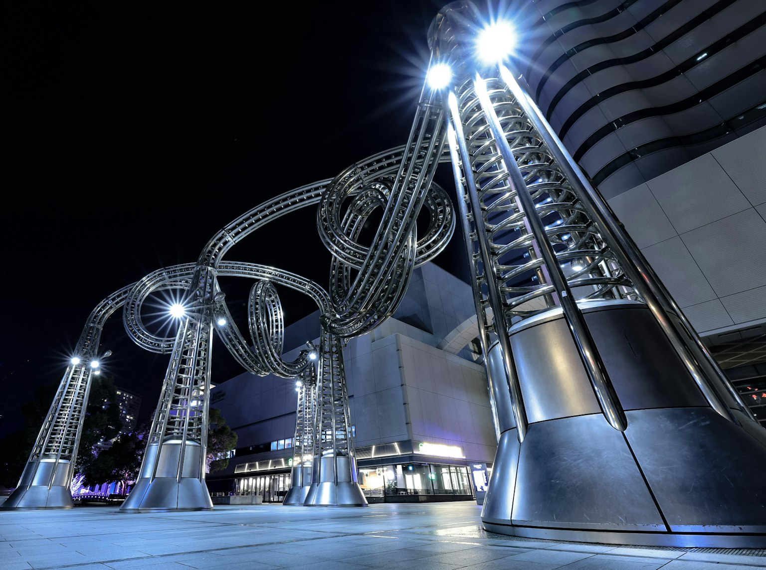 Sculpture d'art métallique moderne dans une ville la nuit