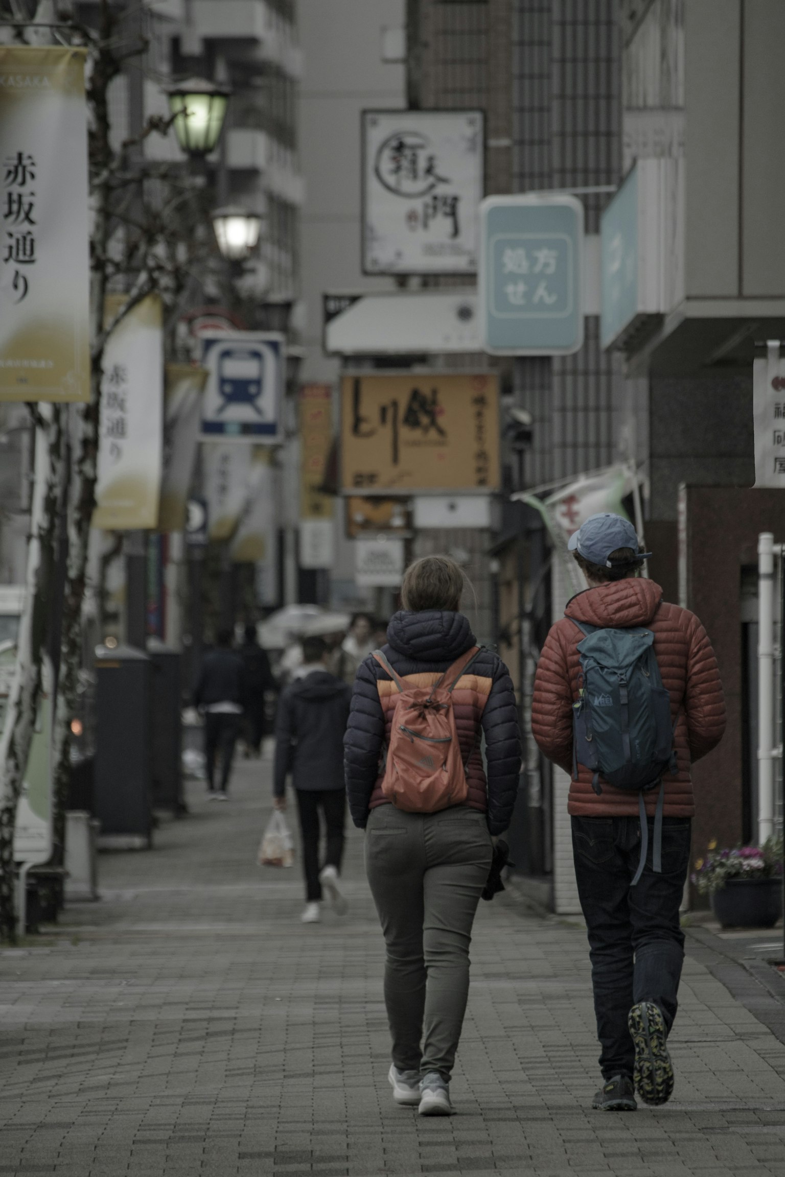 Street scene with people walking two individuals with backpacks walking side by side