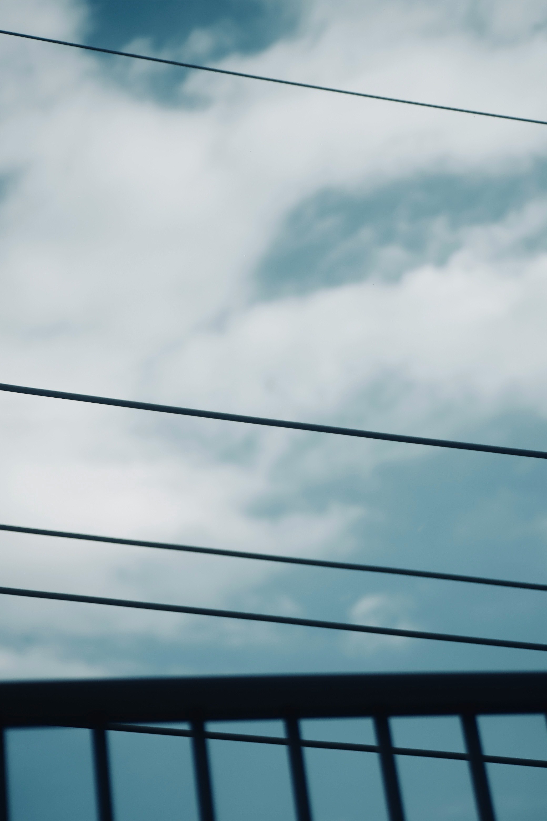青い空と白い雲が見える風景に電線が横たわる