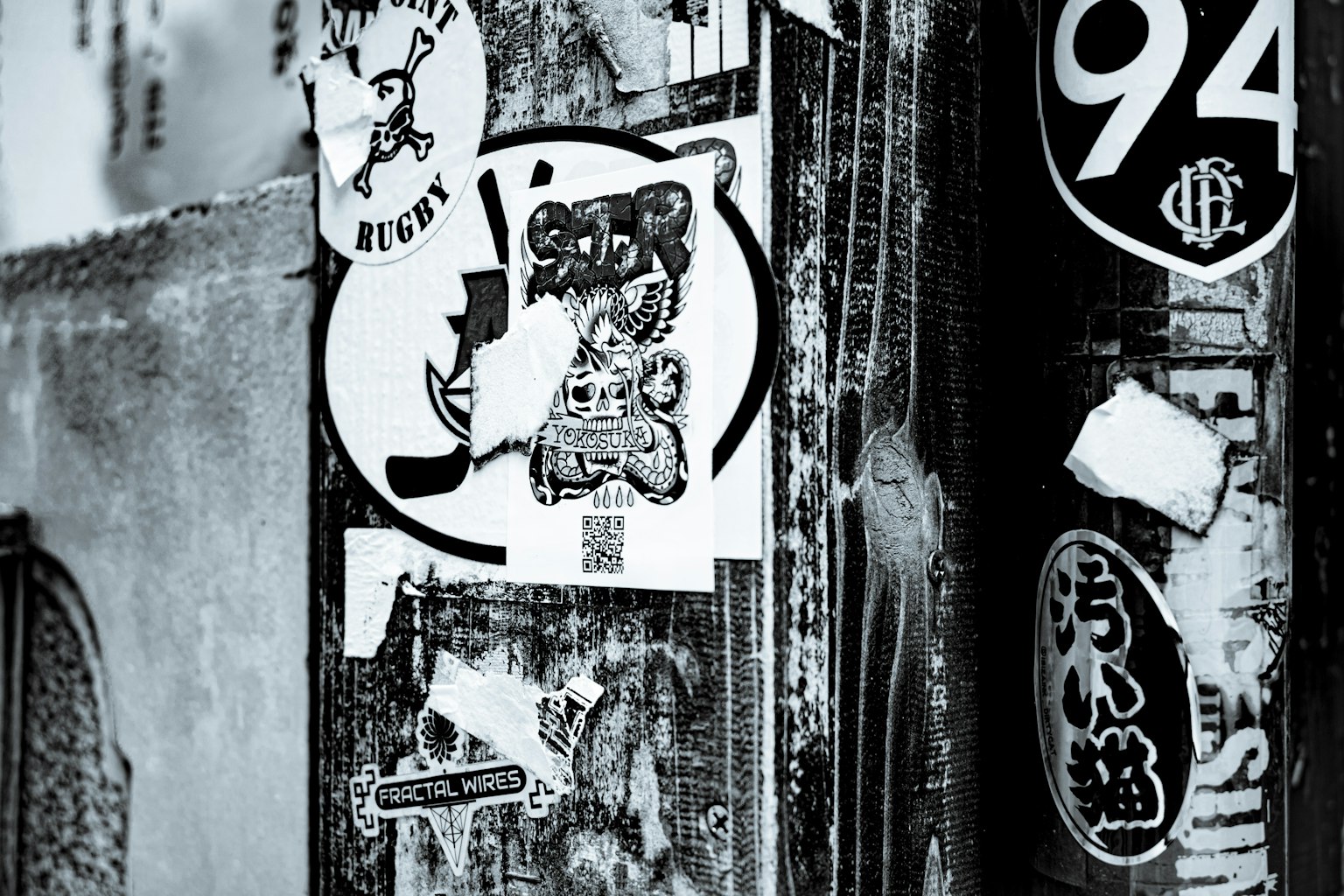 Schwarze und weiße Straßenkunstaufkleber an einer Wand