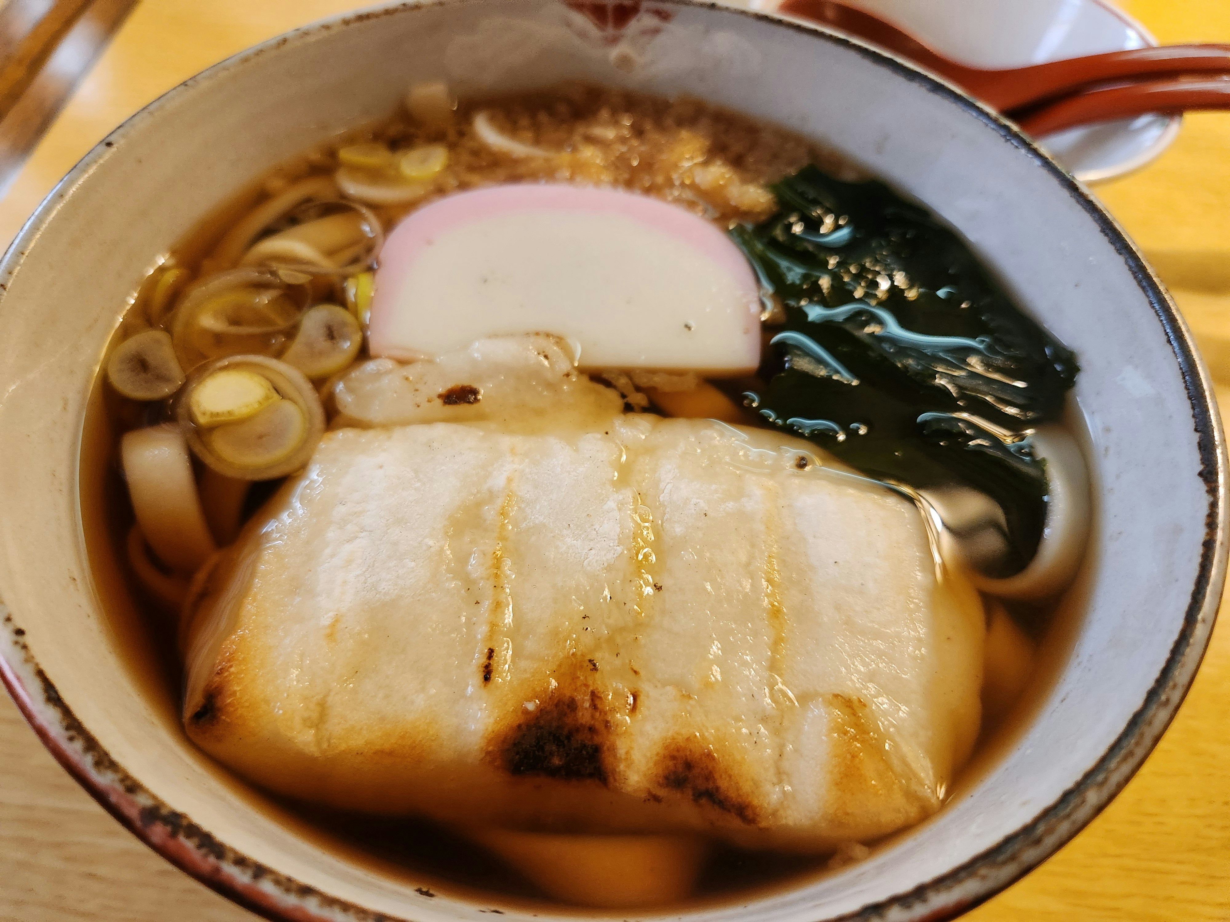 かまぼこ、わかめ、ねぎ、餅入りのうどんのつゆ鍋
