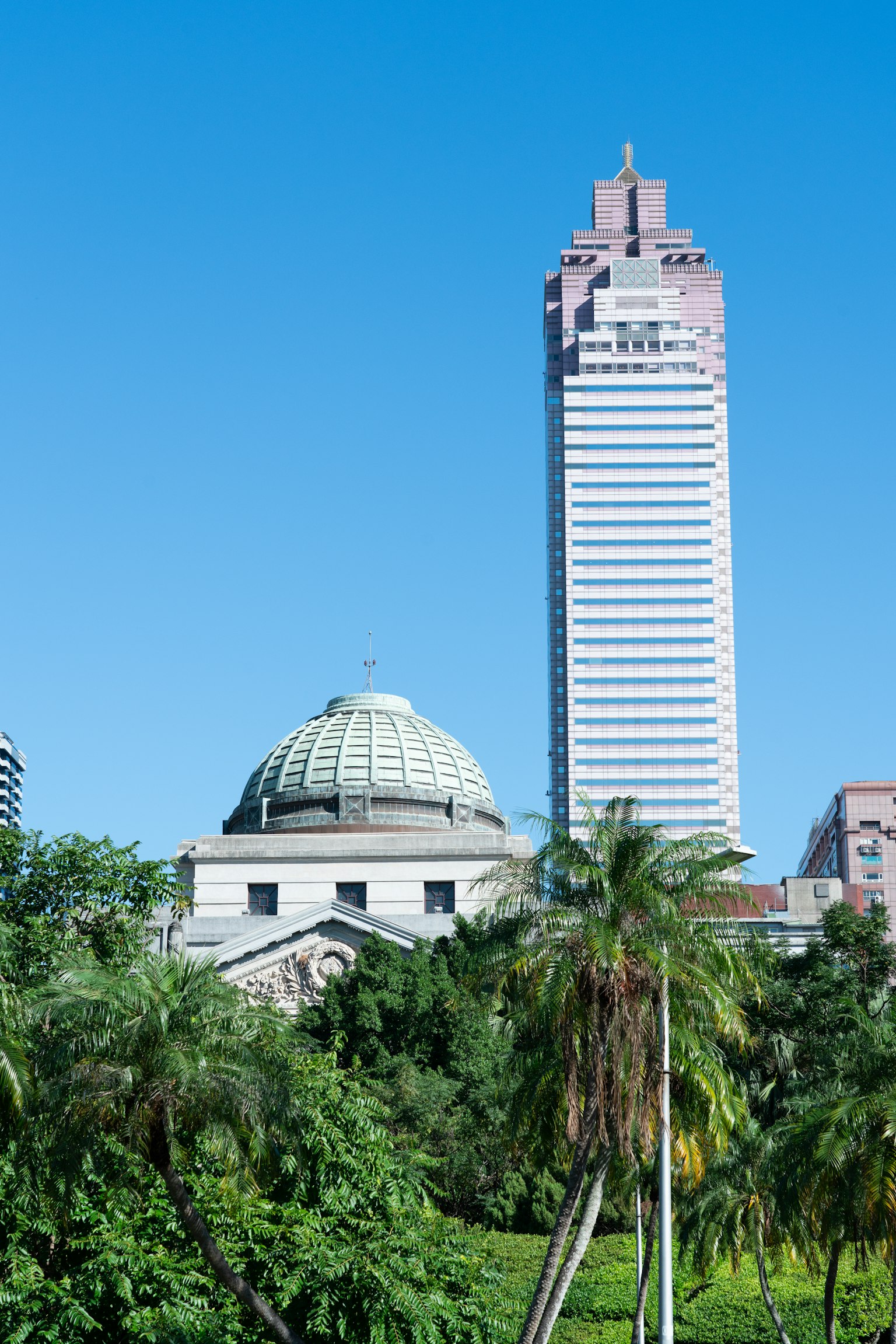 Vista di un grattacielo e di un edificio storico sotto un cielo blu