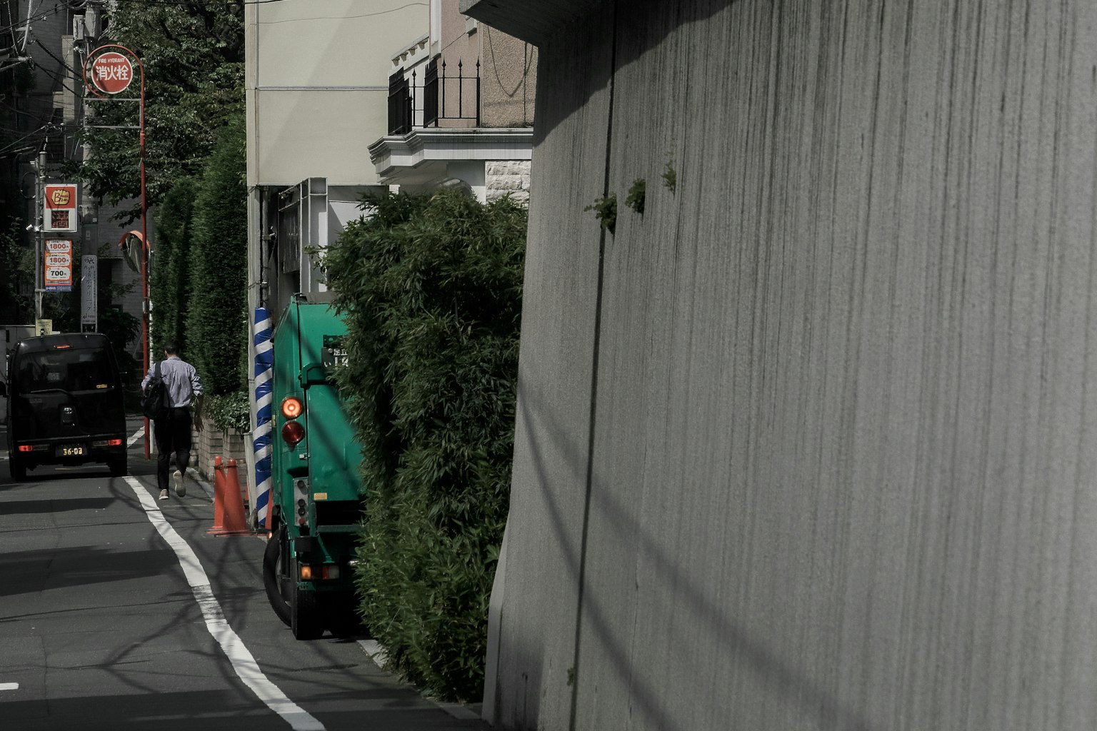 狹窄街道旁停著一輛綠色卡車