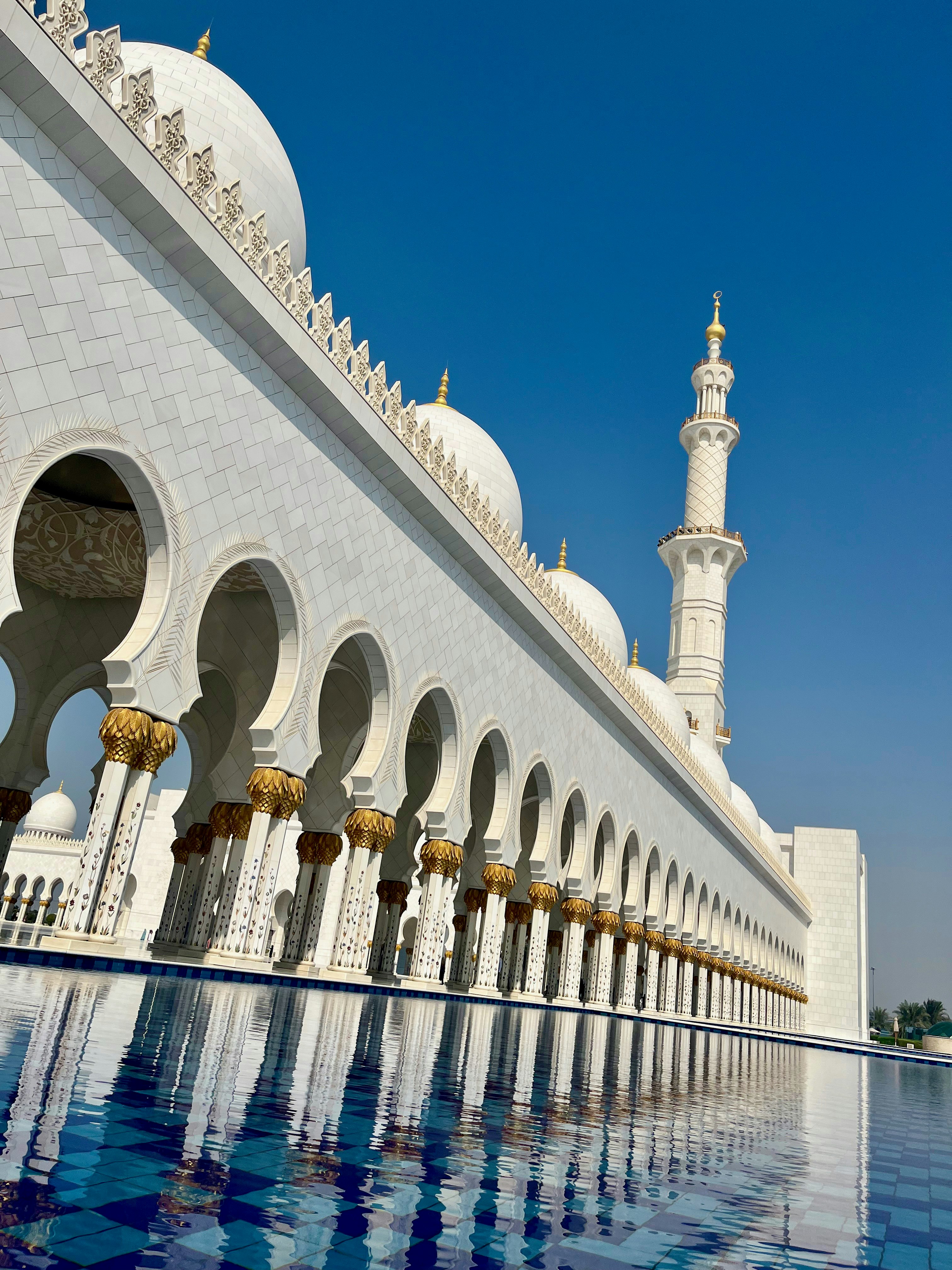 Sheikh Zayed Grand Mosque arches and white facade reflected in water