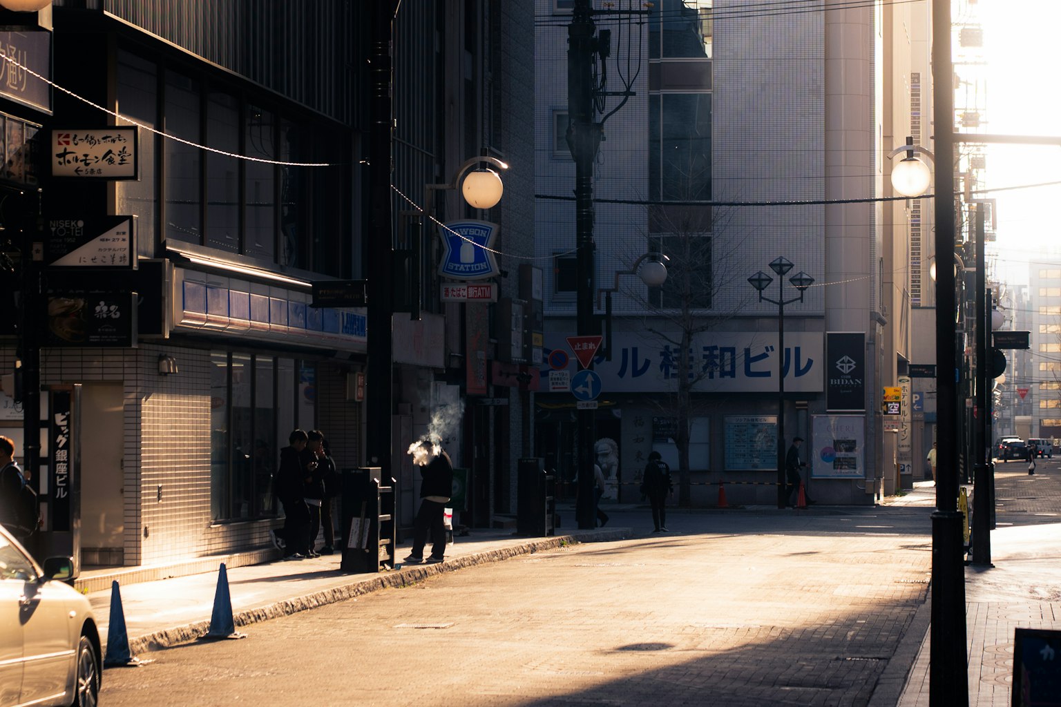 安静的街道场景，有人站立和阳光照射