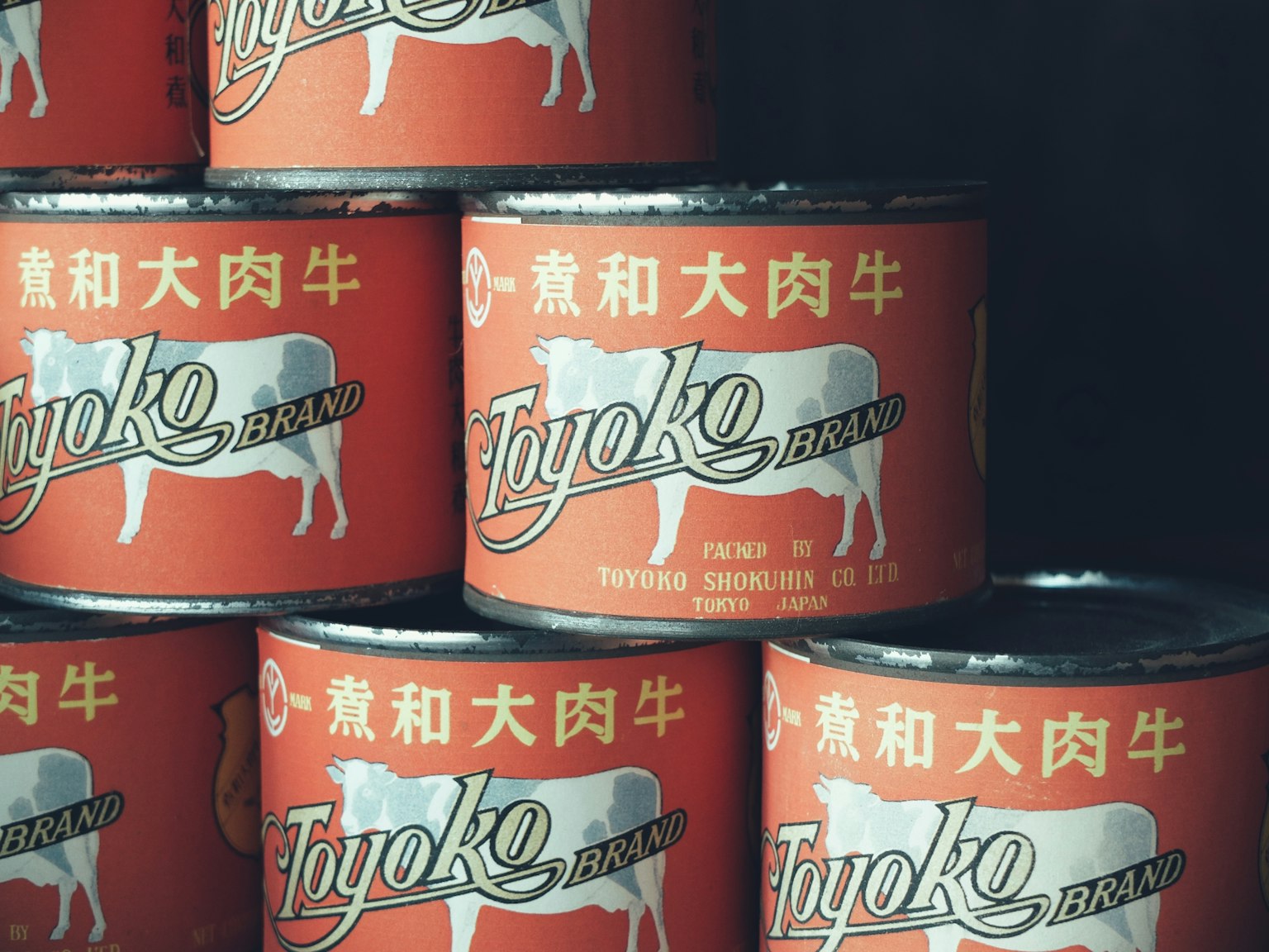 Empilement de boîtes de conserve avec des étiquettes rouges et une illustration de vache