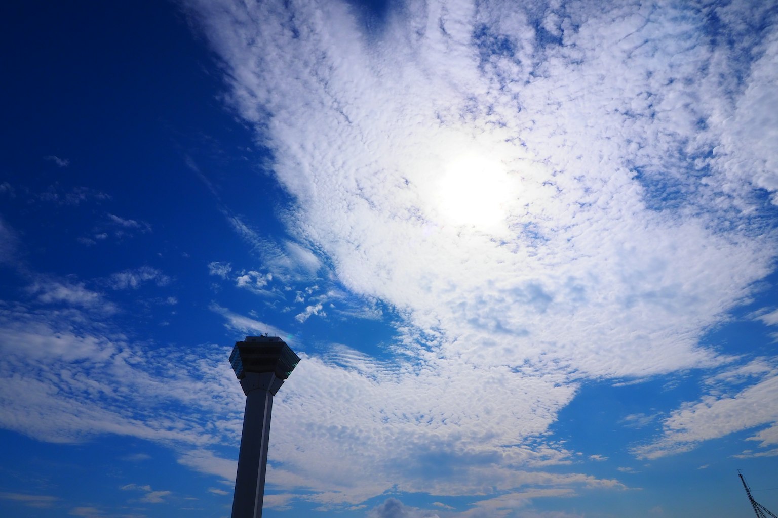 Siluet menara di latar belakang langit biru dengan awan