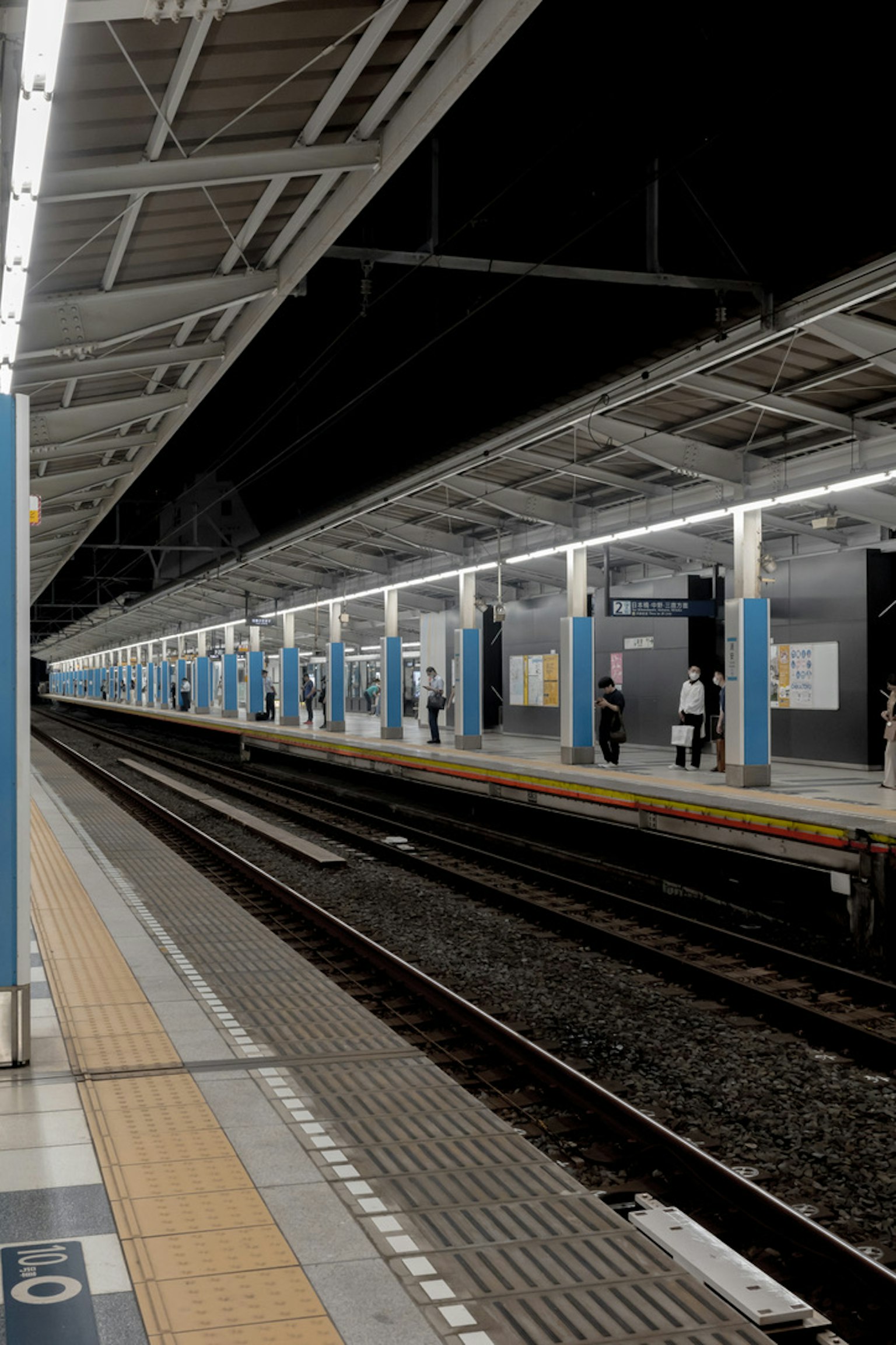 夜間火車站平台景觀 鐵軌和藍色柱子