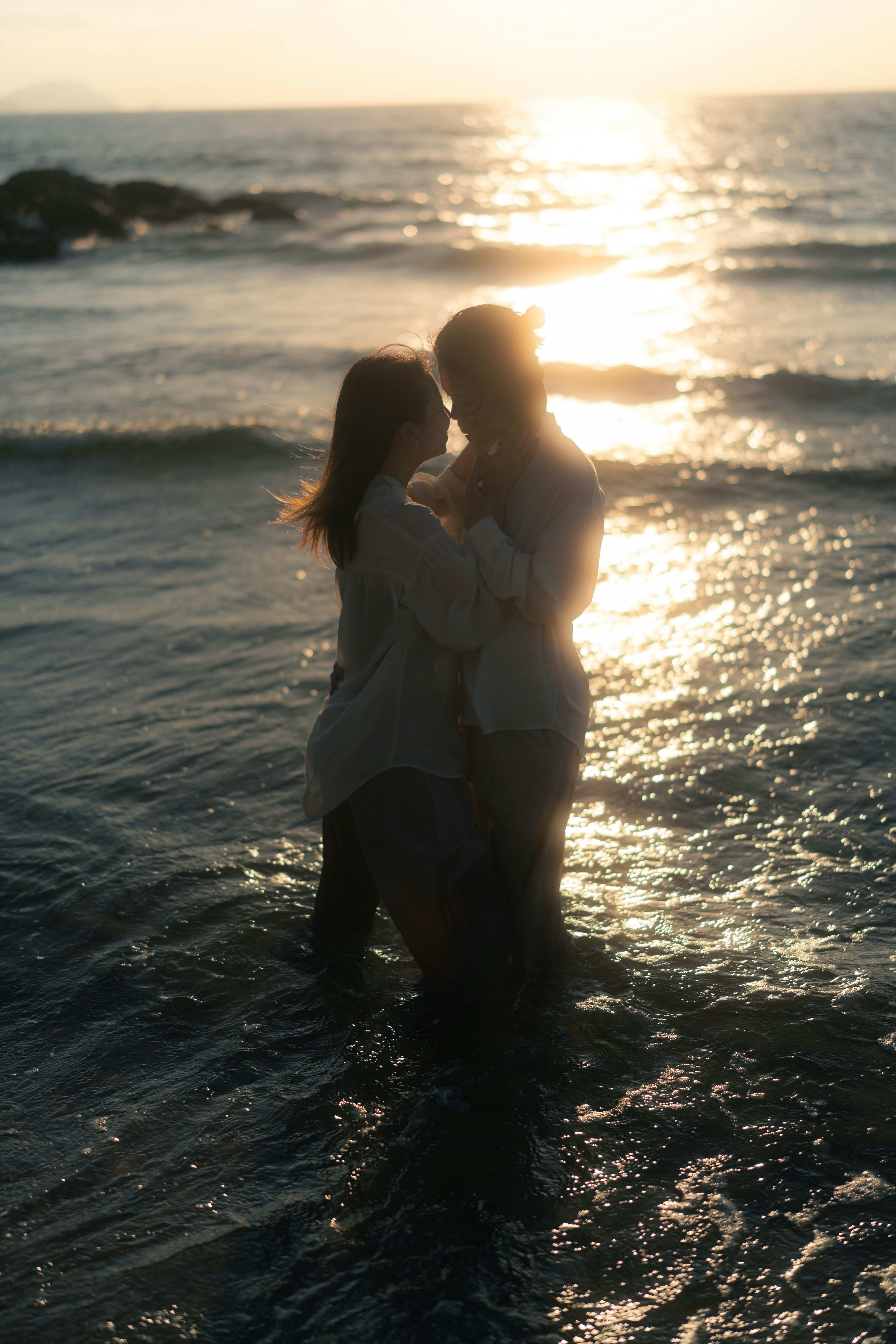 a couple embracing on the beach at sunset