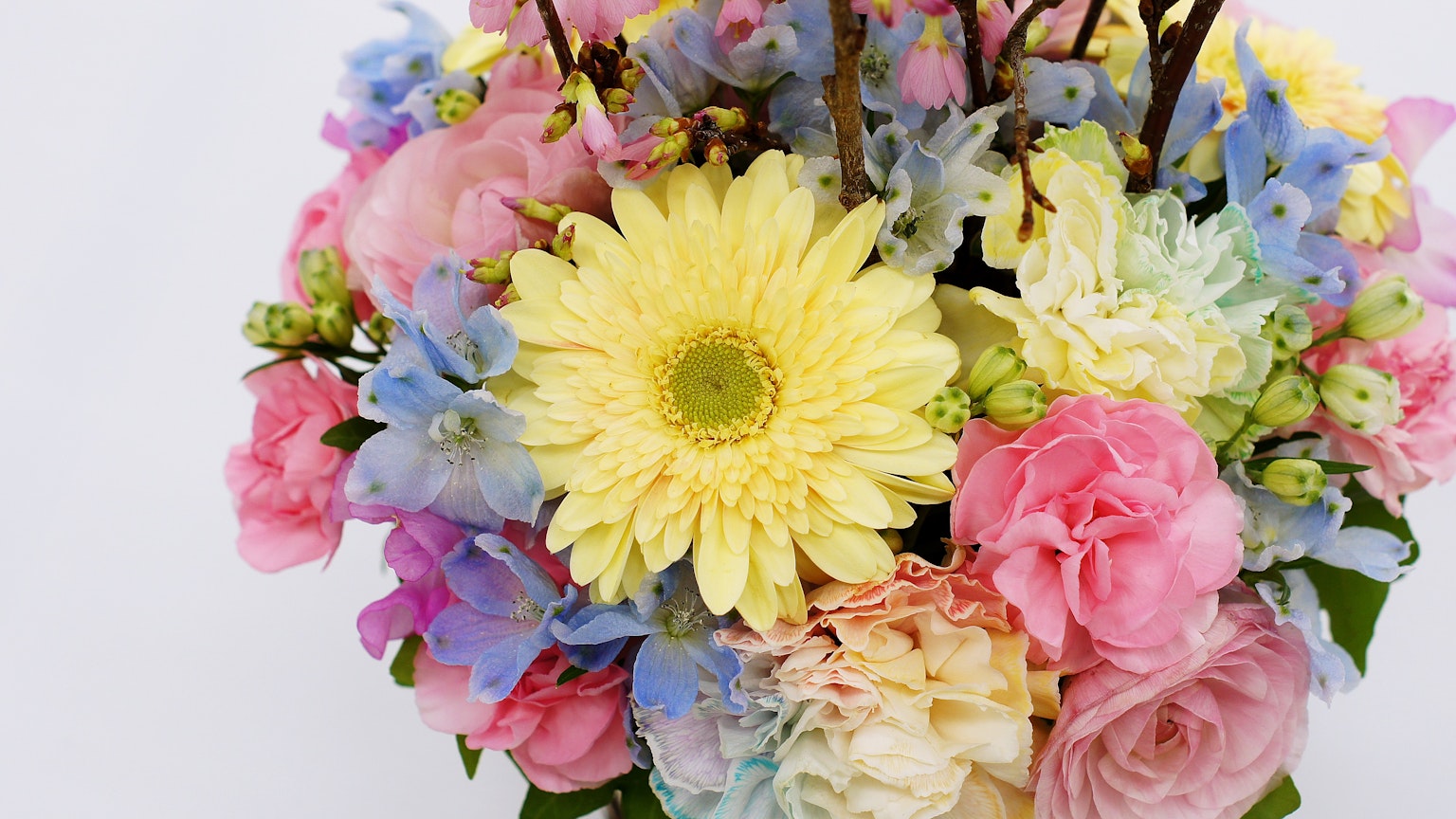 Ein lebhaftes Blumenbouquet mit einer gelben Gerbera und rosa Rosen