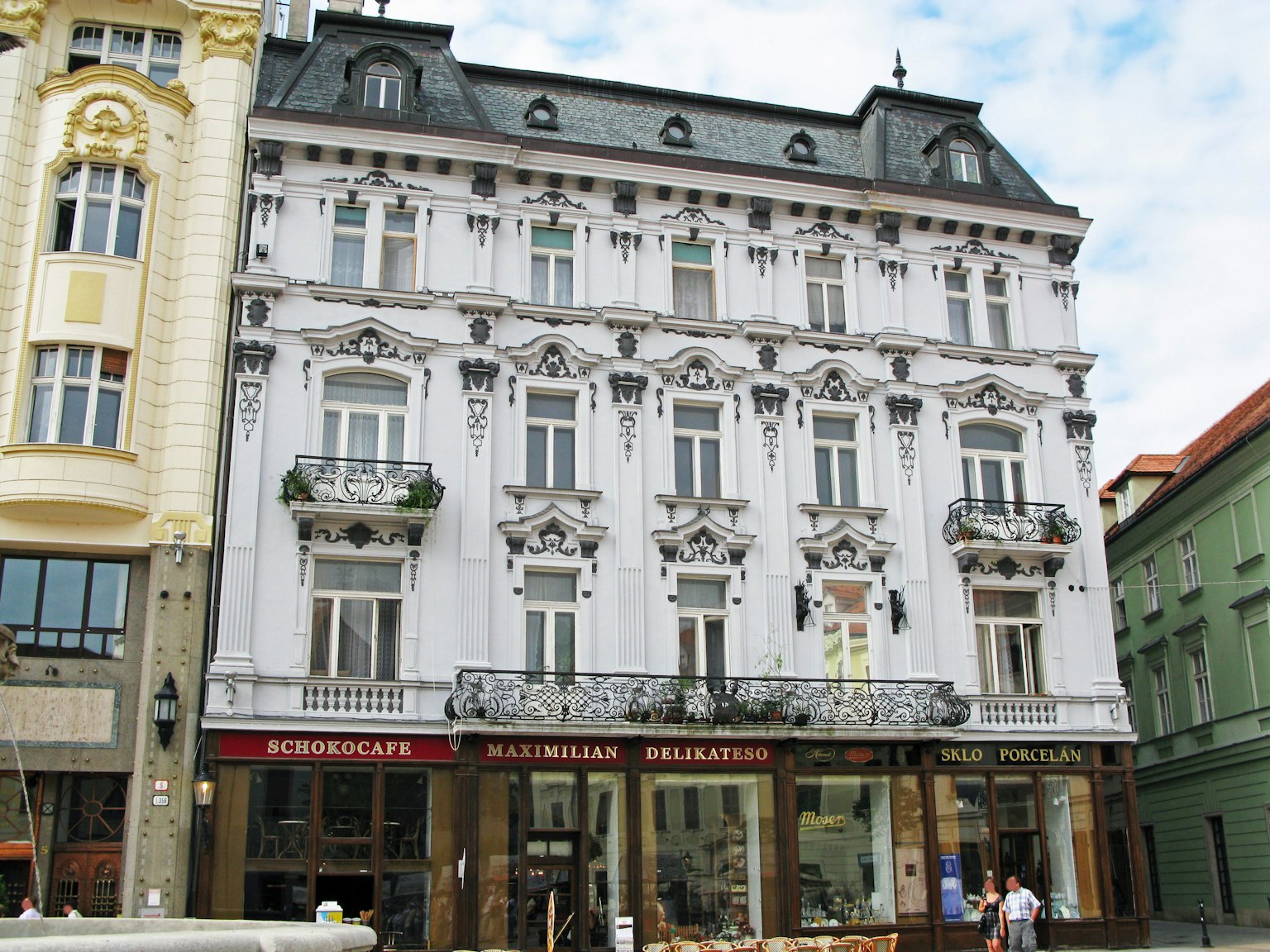 Bâtiment historique avec façade blanche ornée et balcons dans un cadre urbain