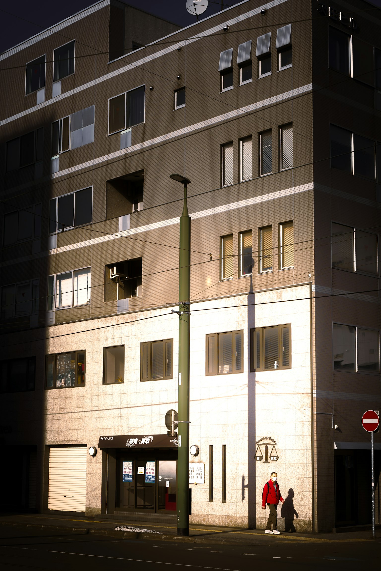 Bâtiment moderne la nuit avec façade illuminée et silhouettes de personnes