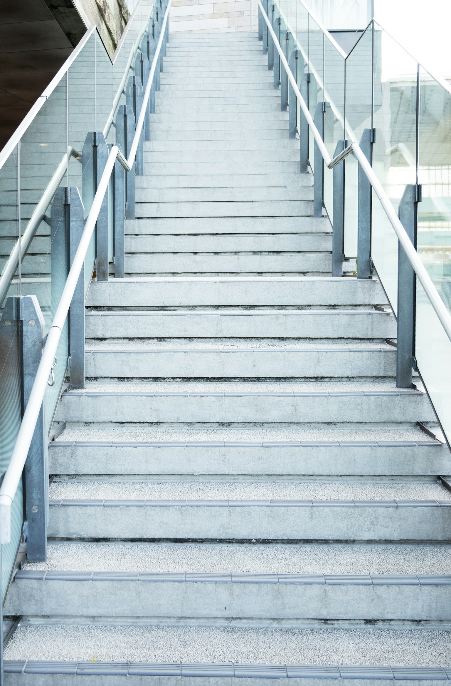 บันไดสมัยใหม่ที่มีขั้นสีขาวและราวโลหะ