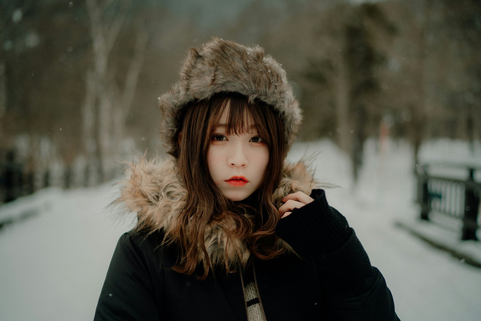 Portrait of a woman wearing a warm hat in the snow