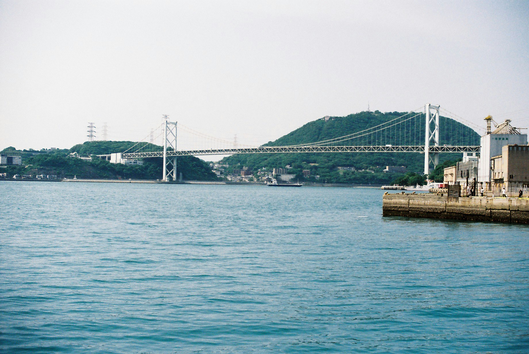 海沿いの港と吊り橋のある風景