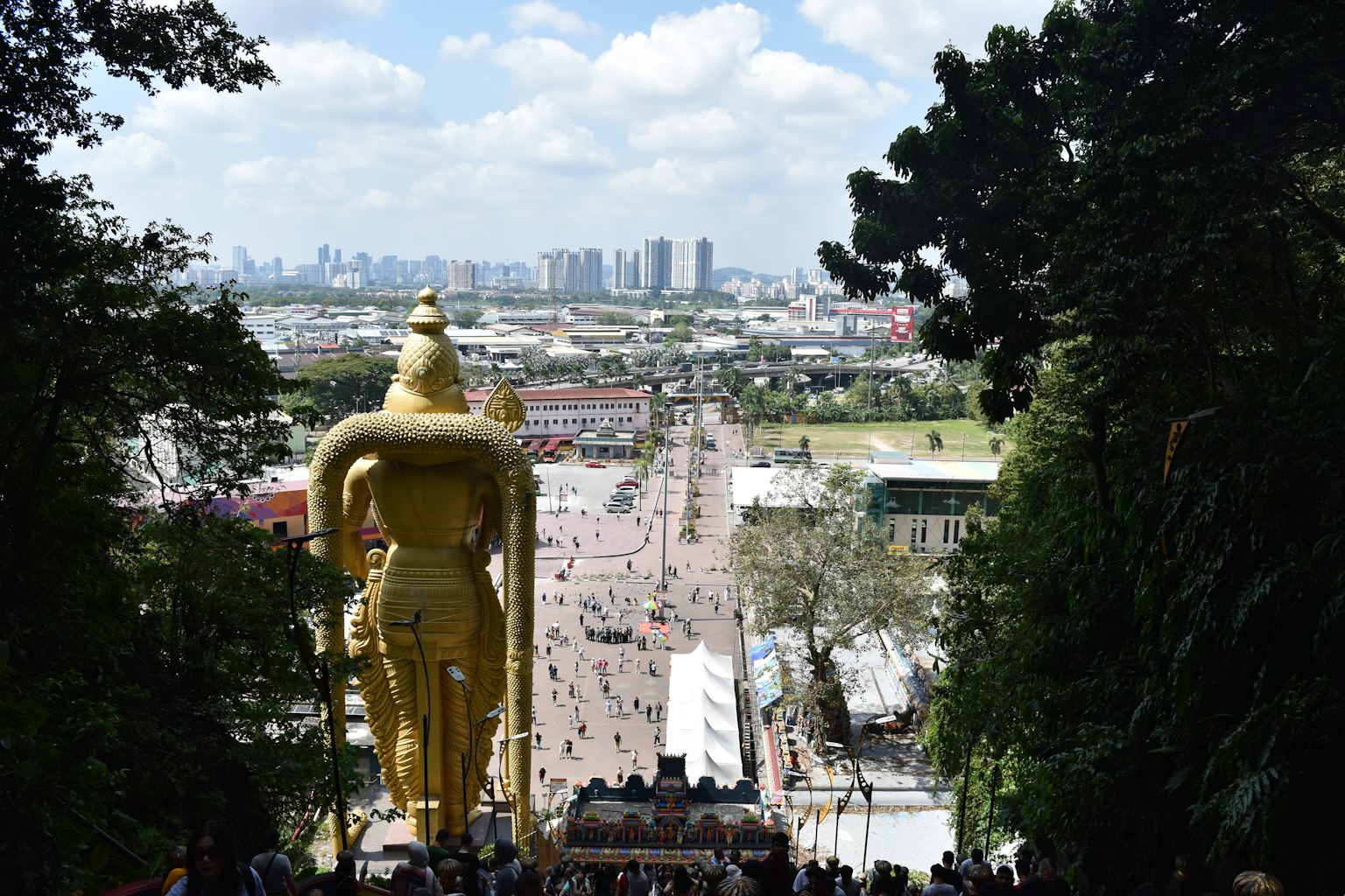Gigante statua di Buddha dorata che sovrasta uno skyline cittadino