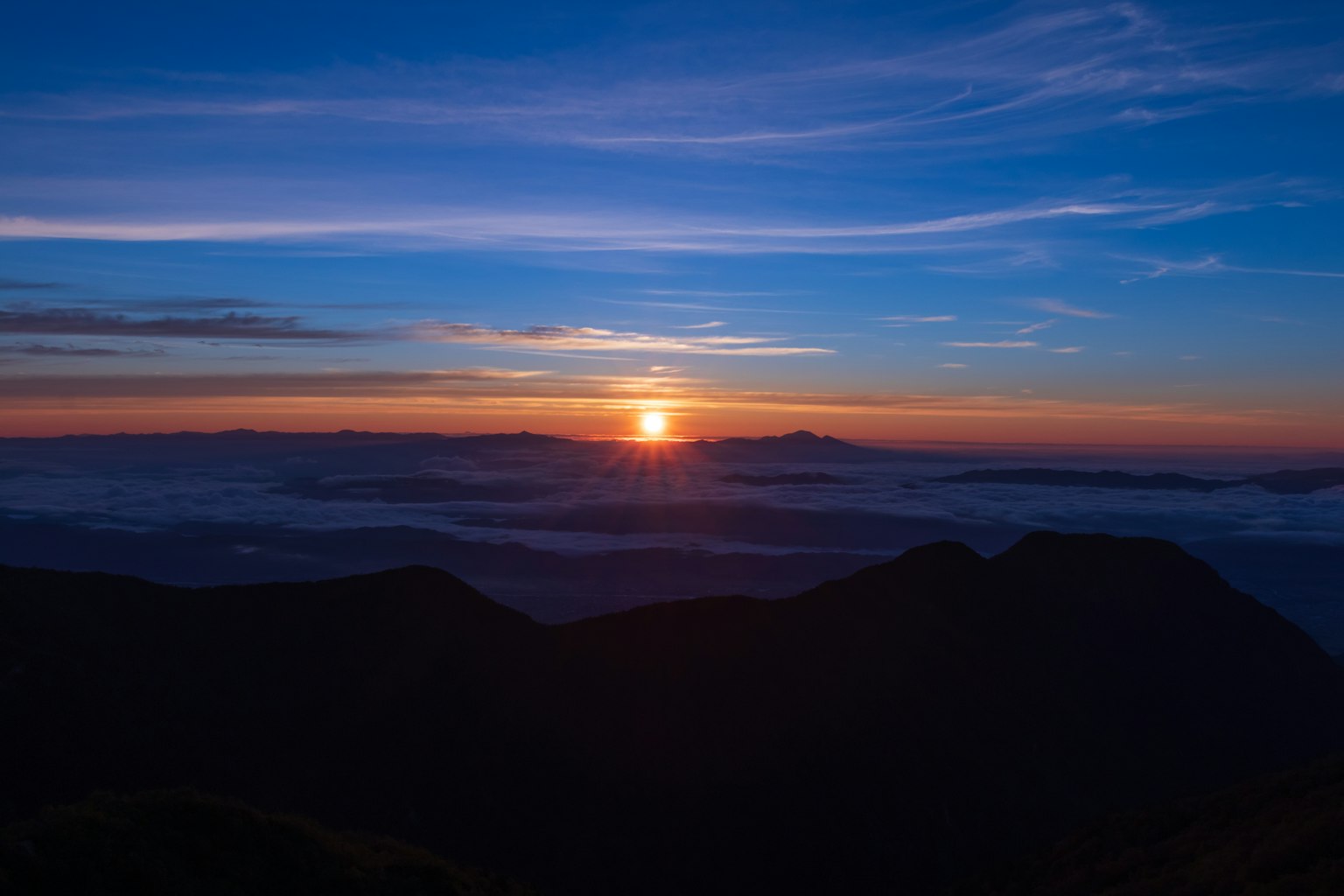 美麗的日出景觀，各種藍色天空和雲朵，太陽在山間升起