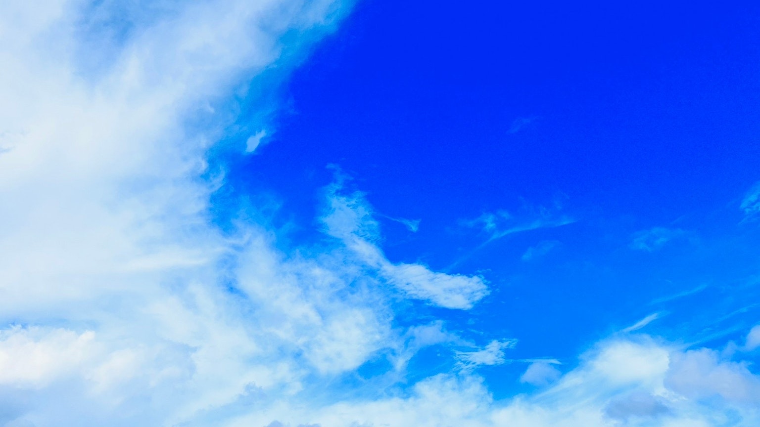Un ciel bleu vif avec des nuages blancs éparpillés