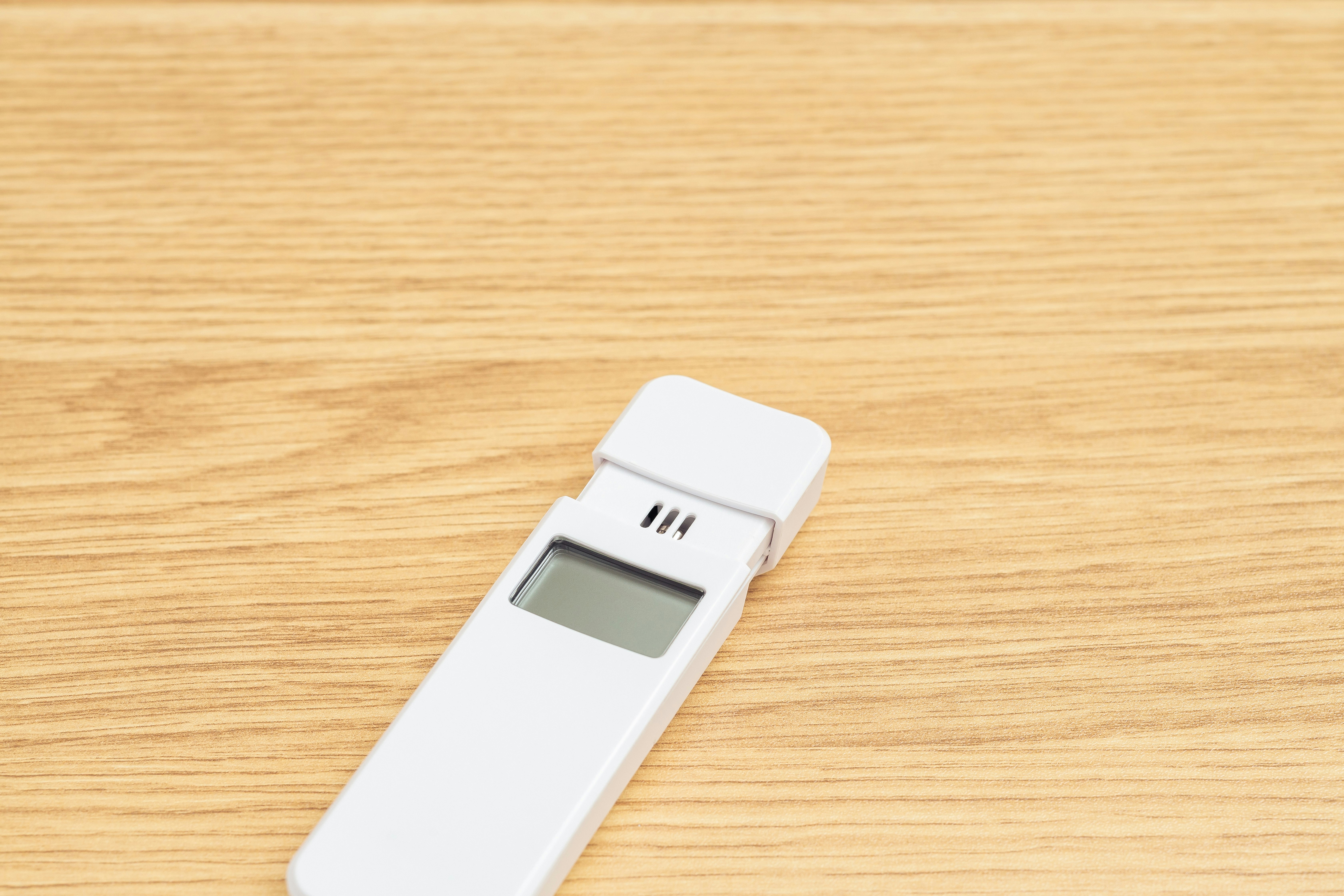 木の机の上に置かれた電子体温計