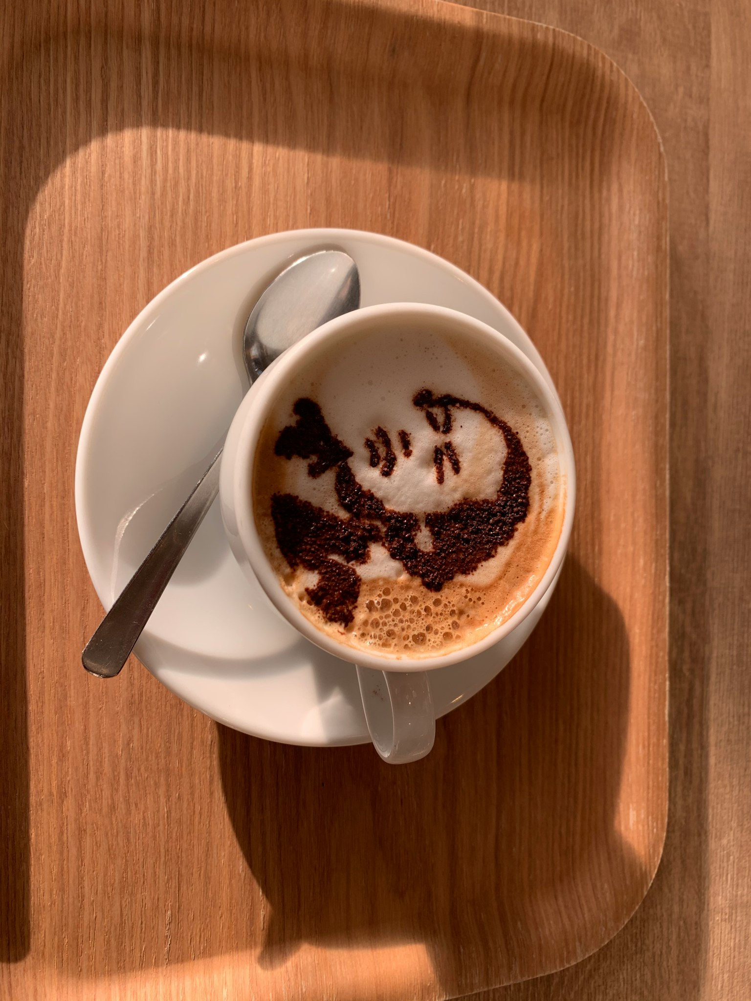 Image of a coffee cup with artistic face design on the surface