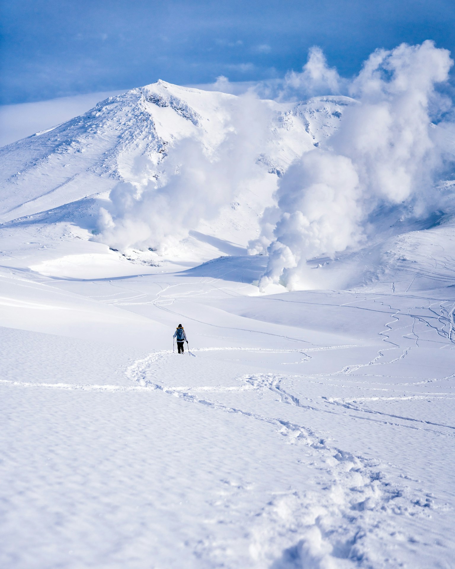被雪覆蓋的山脈風景和冒煙的火山