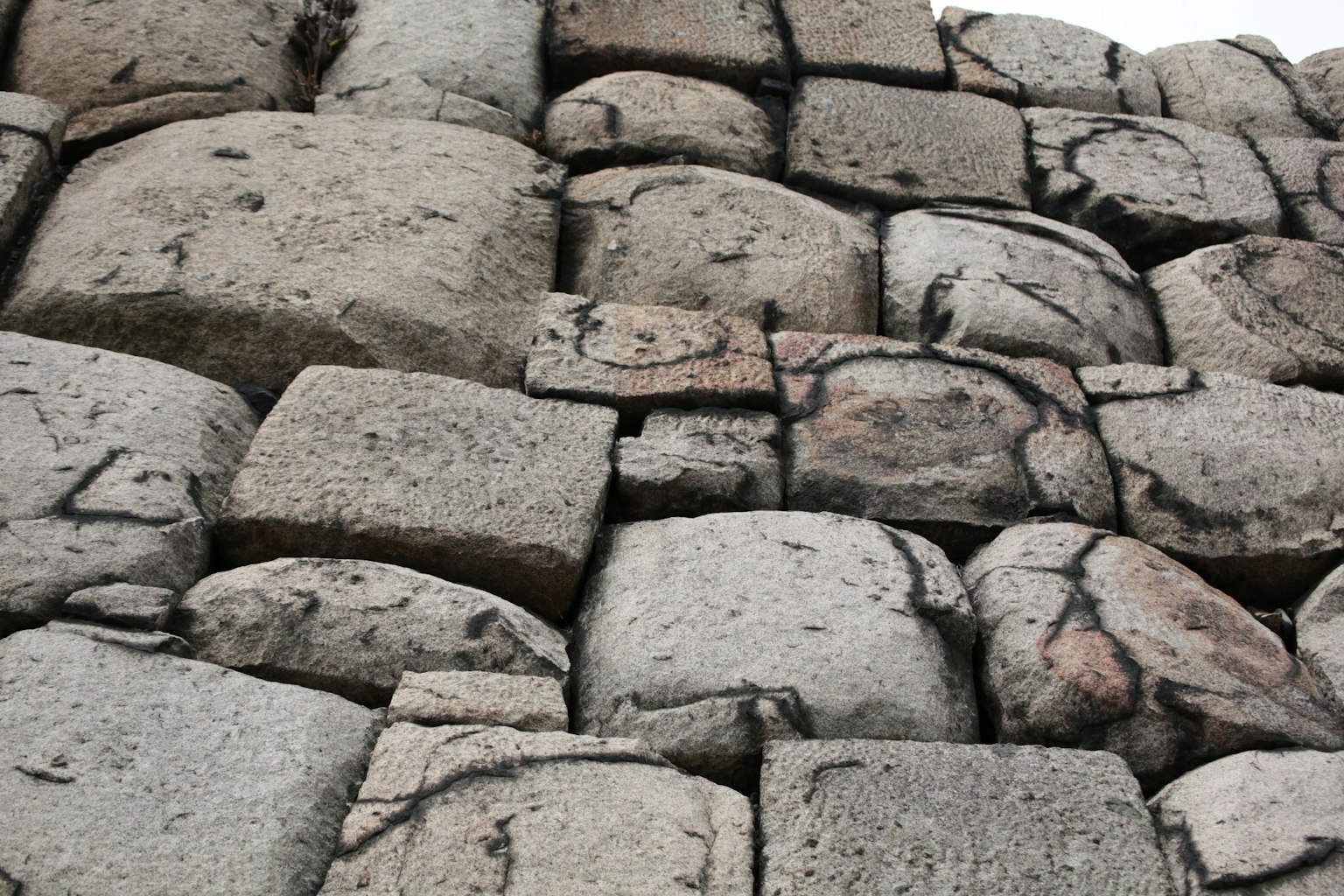 Acercamiento de un muro de piedra antiguo con piedras grises apiladas