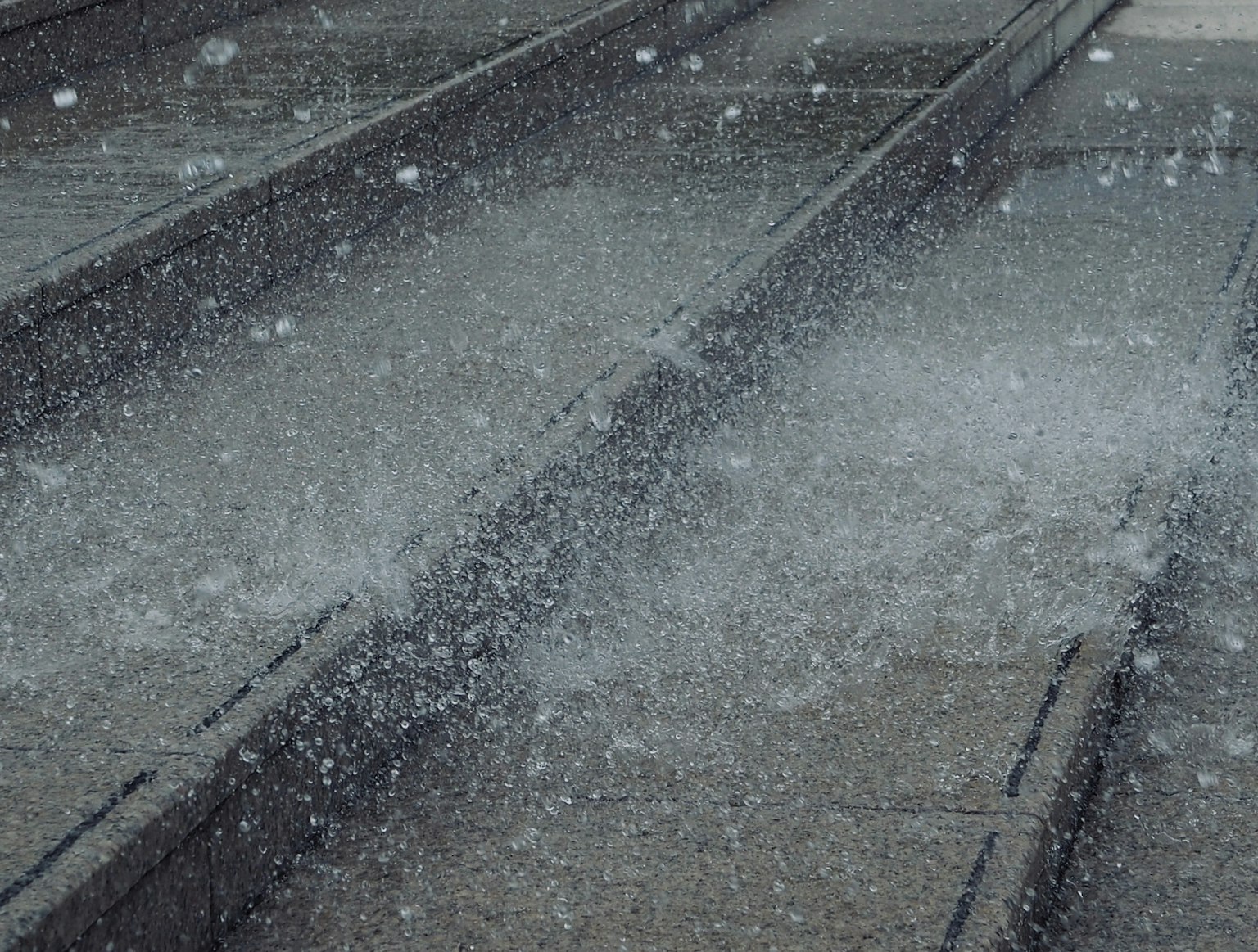 Teil von Eisenbahnschienen mit Wasserspritzern im Regen
