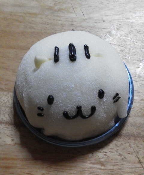 白いケーキの上に黒いデコレーションが並ぶ