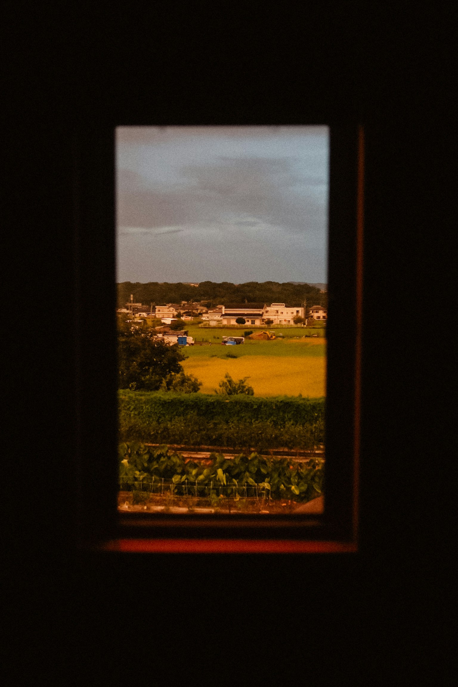 窓から見える田園風景と家々の景色