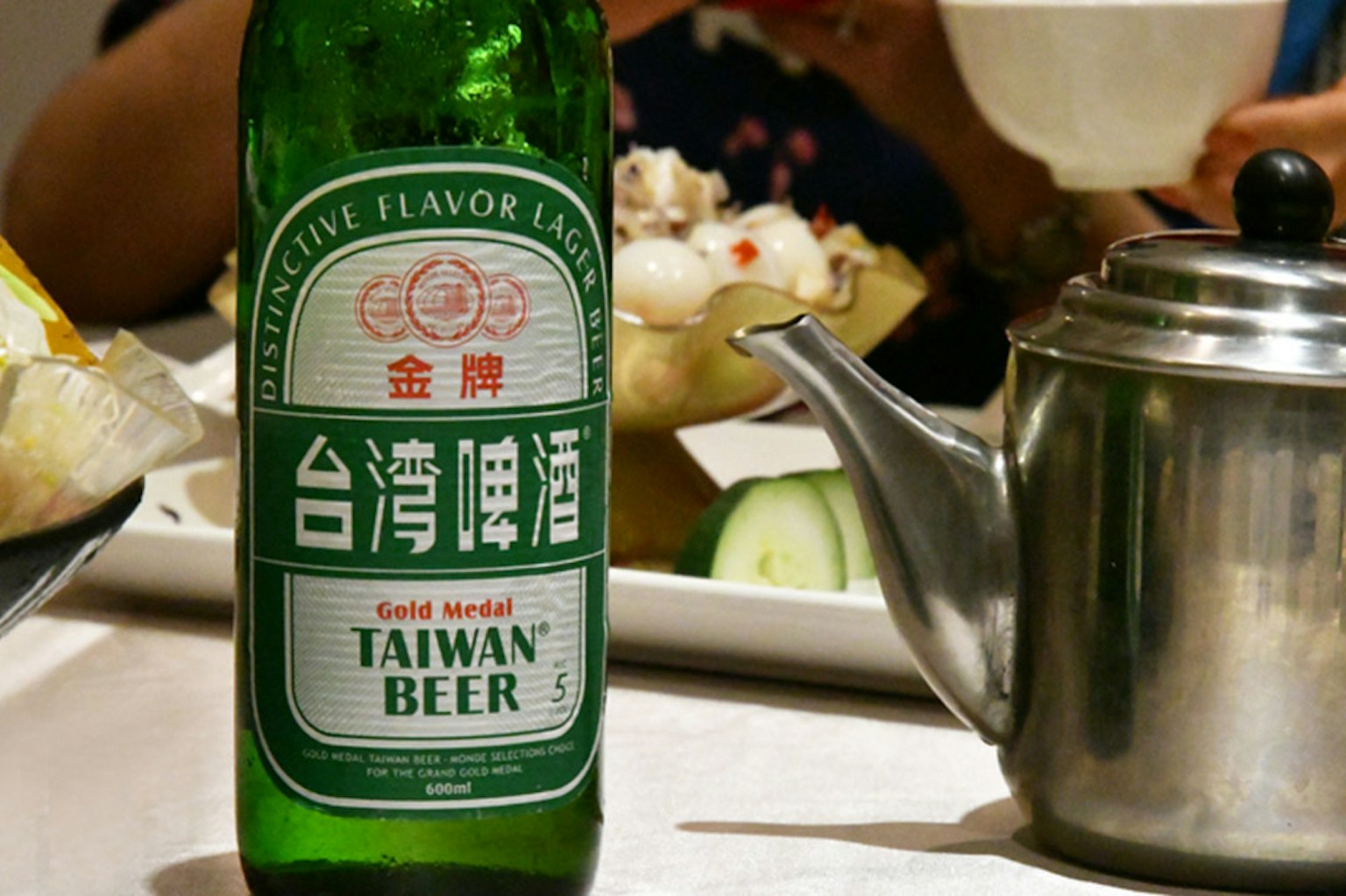 餐桌上的台湾啤酒绿瓶和茶壶