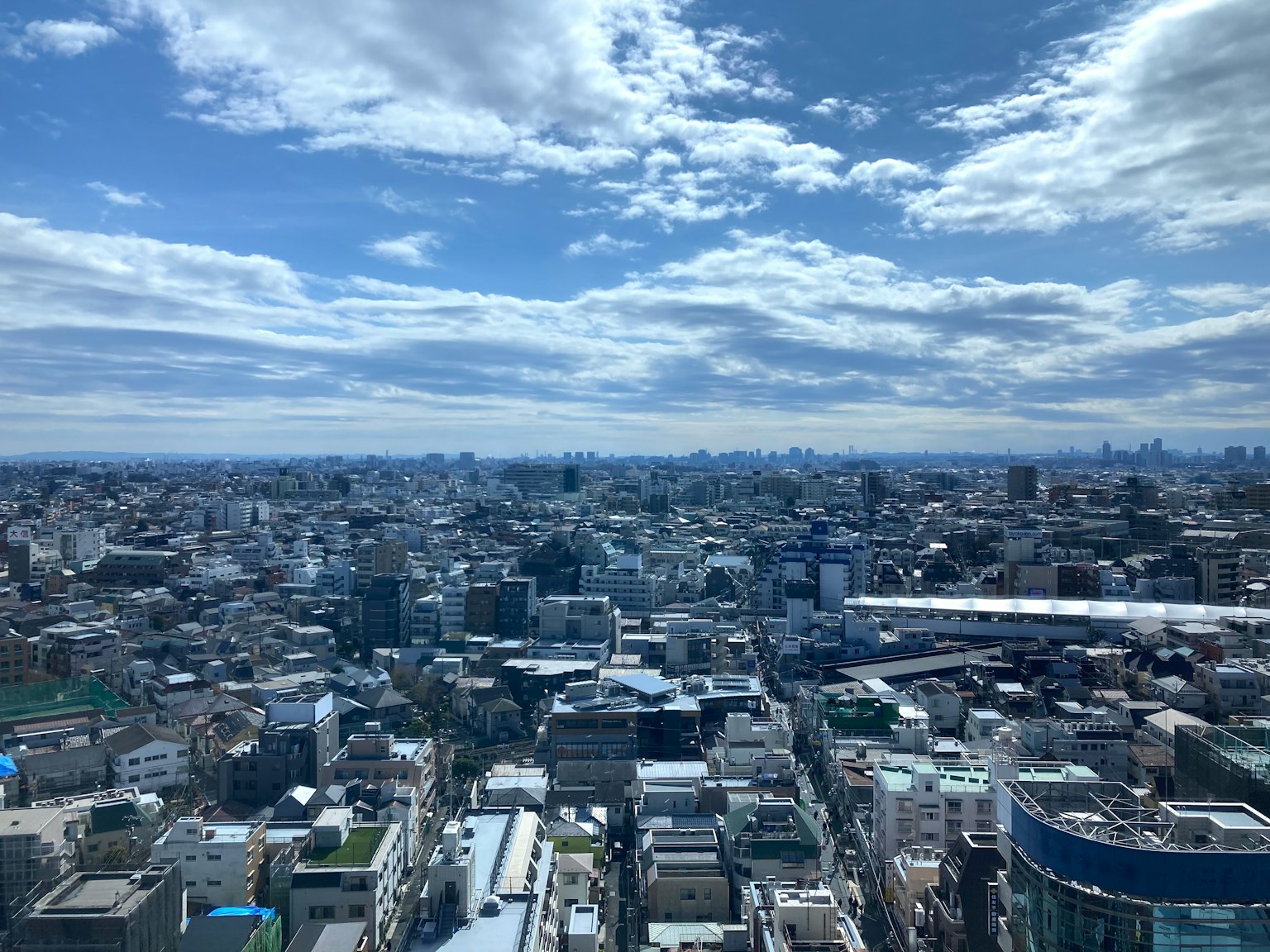Pemandangan Tokyo dari gedung tinggi, langit biru dan awan, kota yang luas